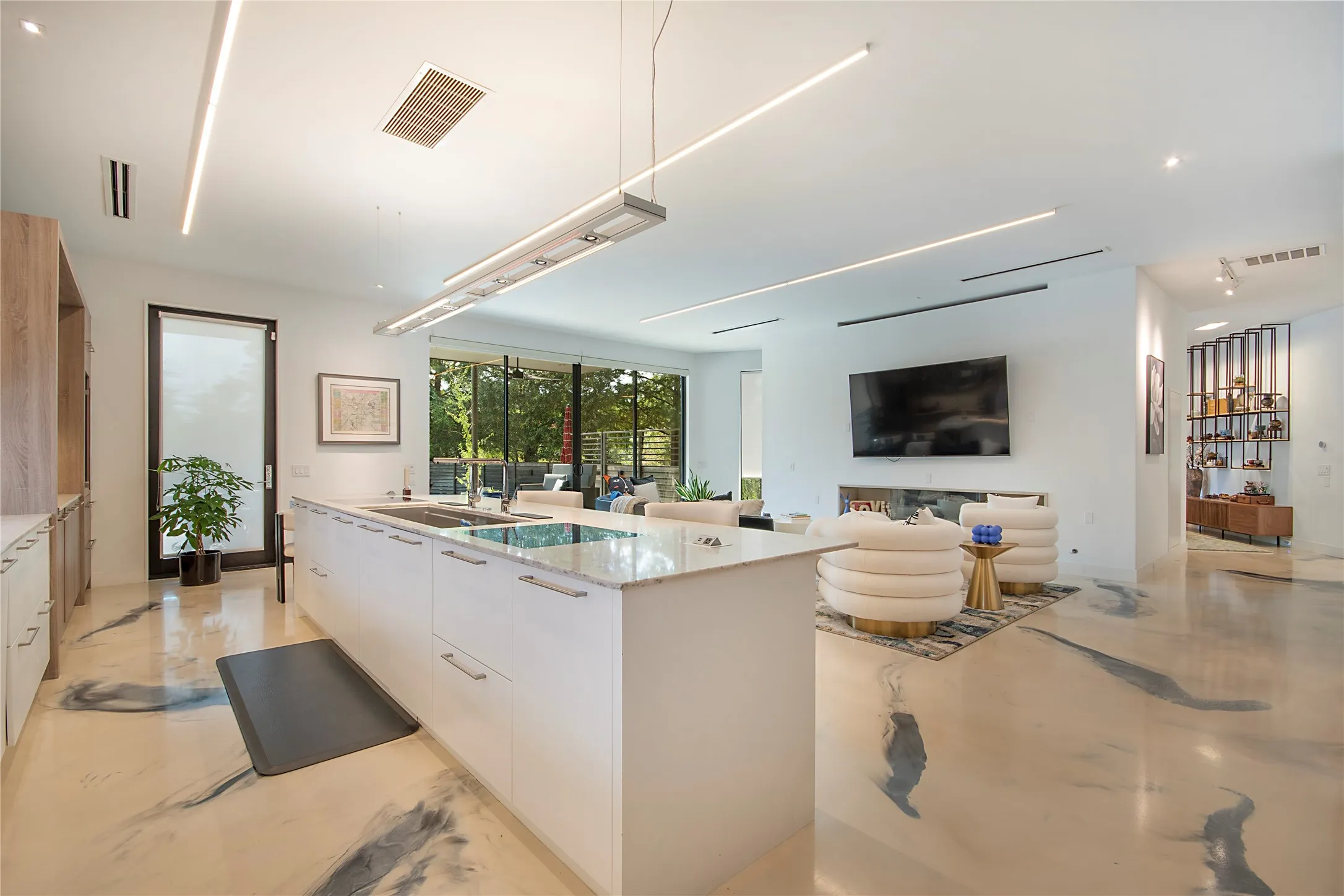 Gourmet kitchen island with an integrated cooktop and undermount sink, complemented by white cabinetry and stone countertops