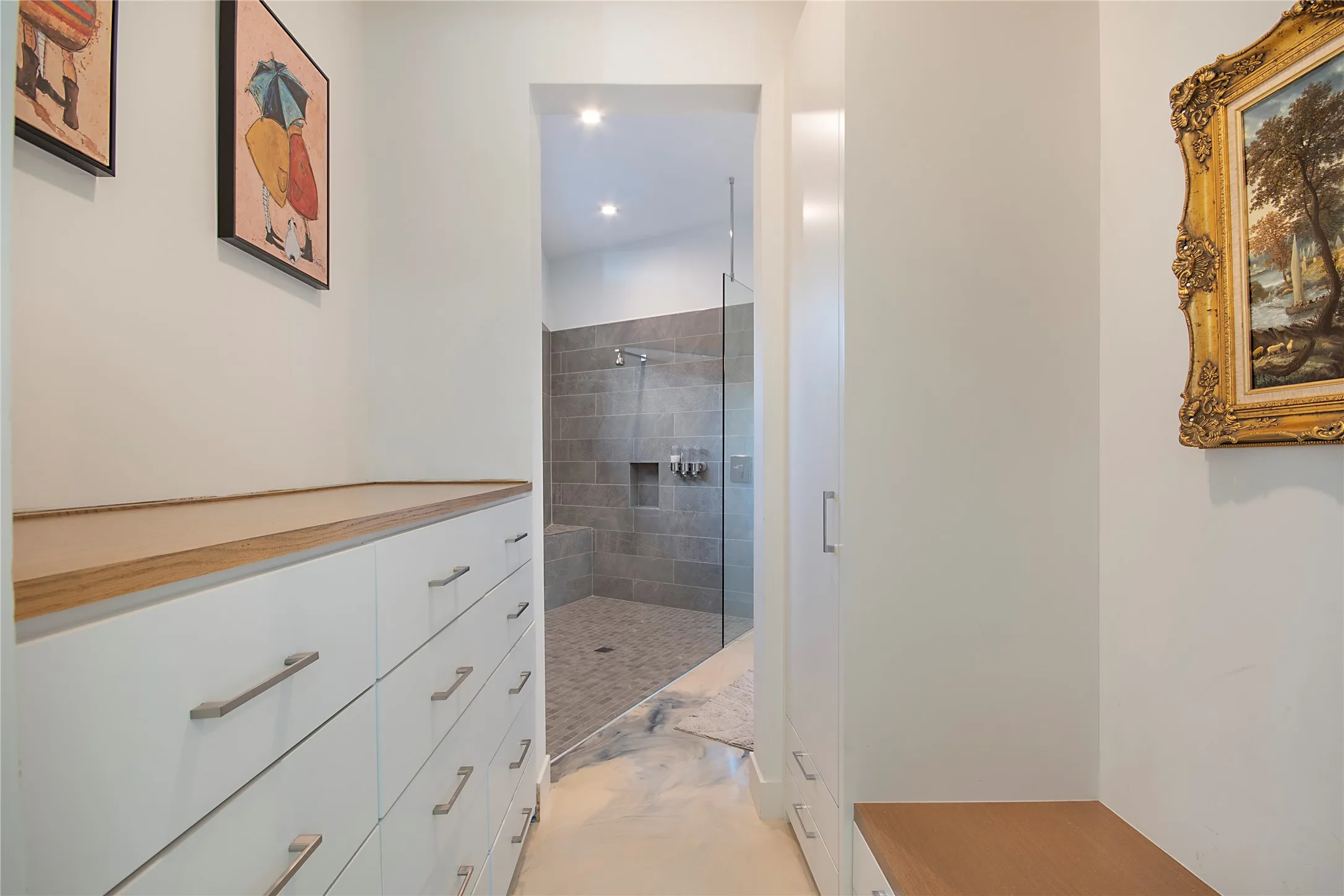 Walk-through closet with built-in drawers, wood-finish countertop, and integrated wardrobe