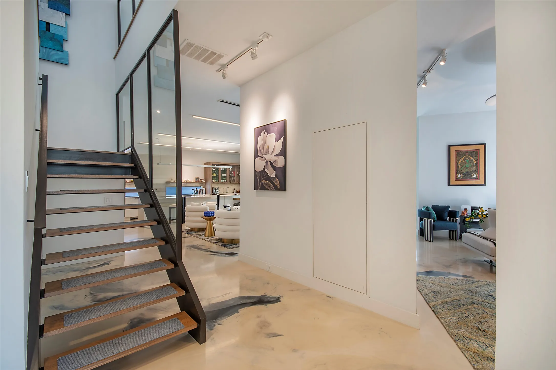 Open-tread staircase with wood-finish treads and a glass panel railing