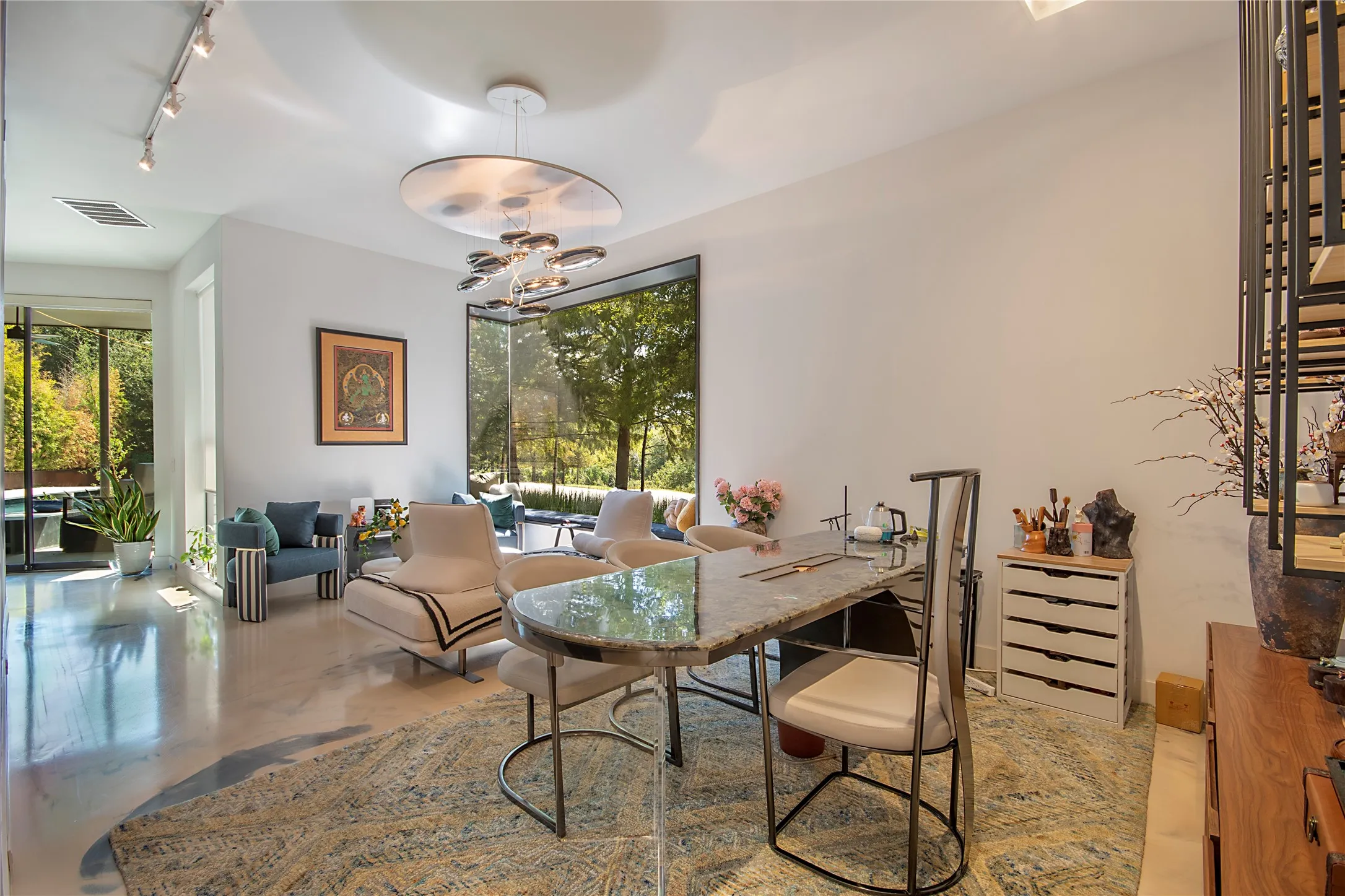 Polished concrete flooring, recessed lighting, floor-to-ceiling windows, and a modern chandelier