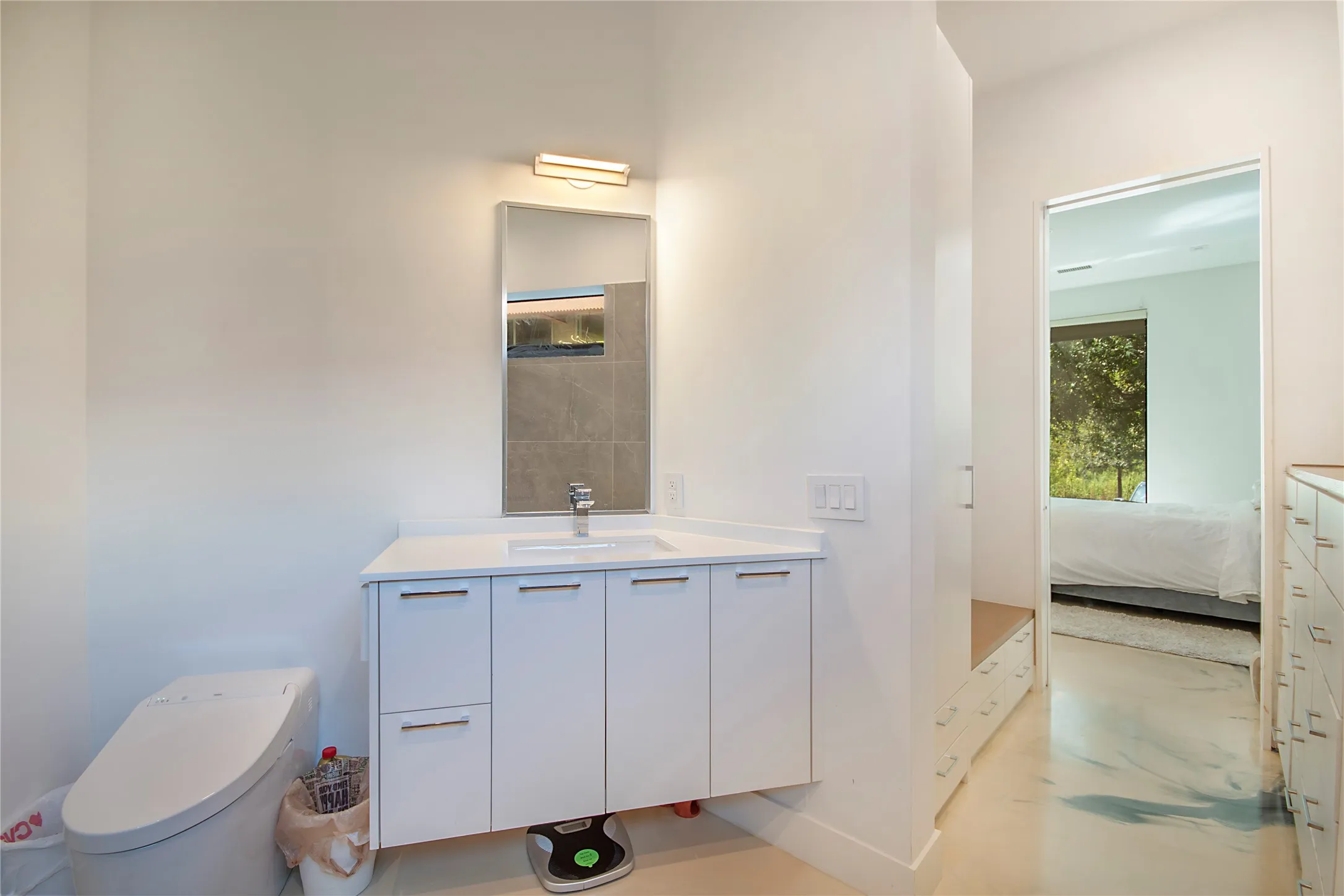White vanity with under-mount sink, integrated countertop, and modern hardware