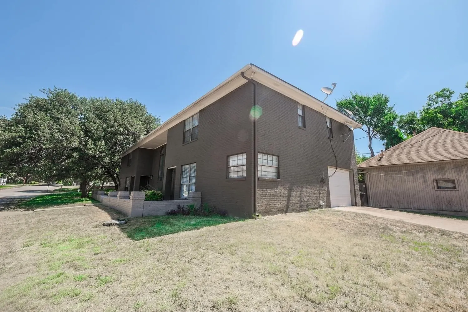 Two-story brick exterior with a side-facing garage and a separate detached garage structure