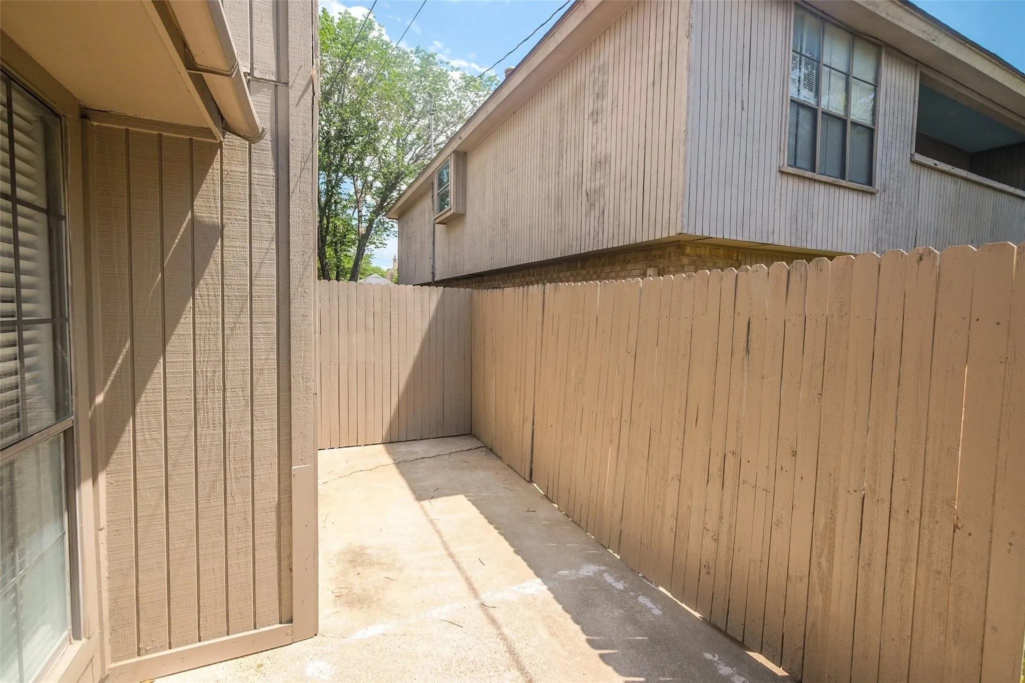 Enclosed patio featuring privacy fencing and a concrete surface