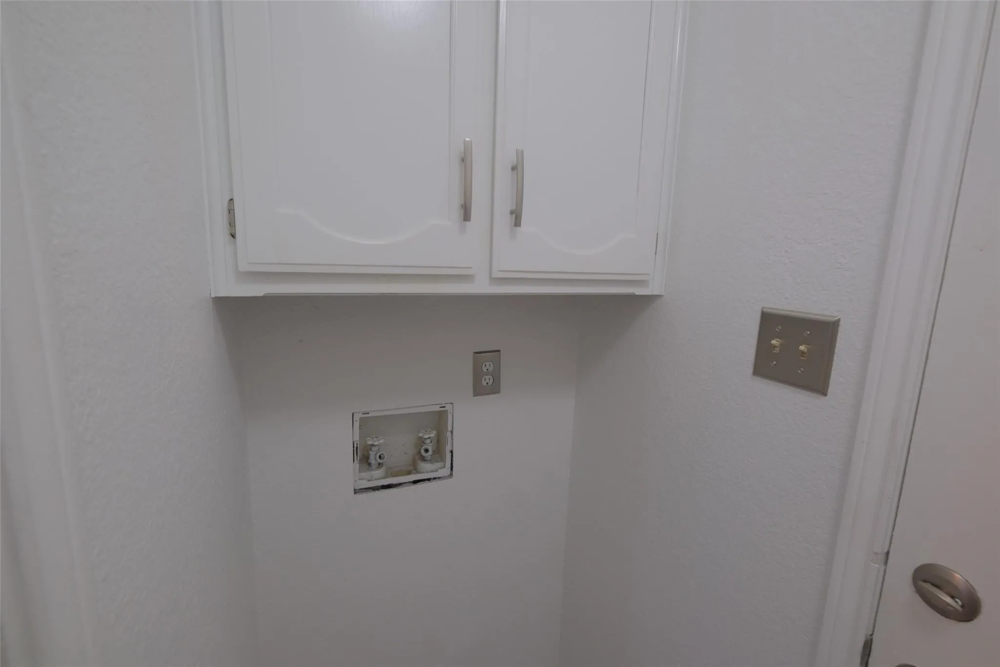 White shaker-style cabinetry with brushed nickel hardware and a dedicated utility area
