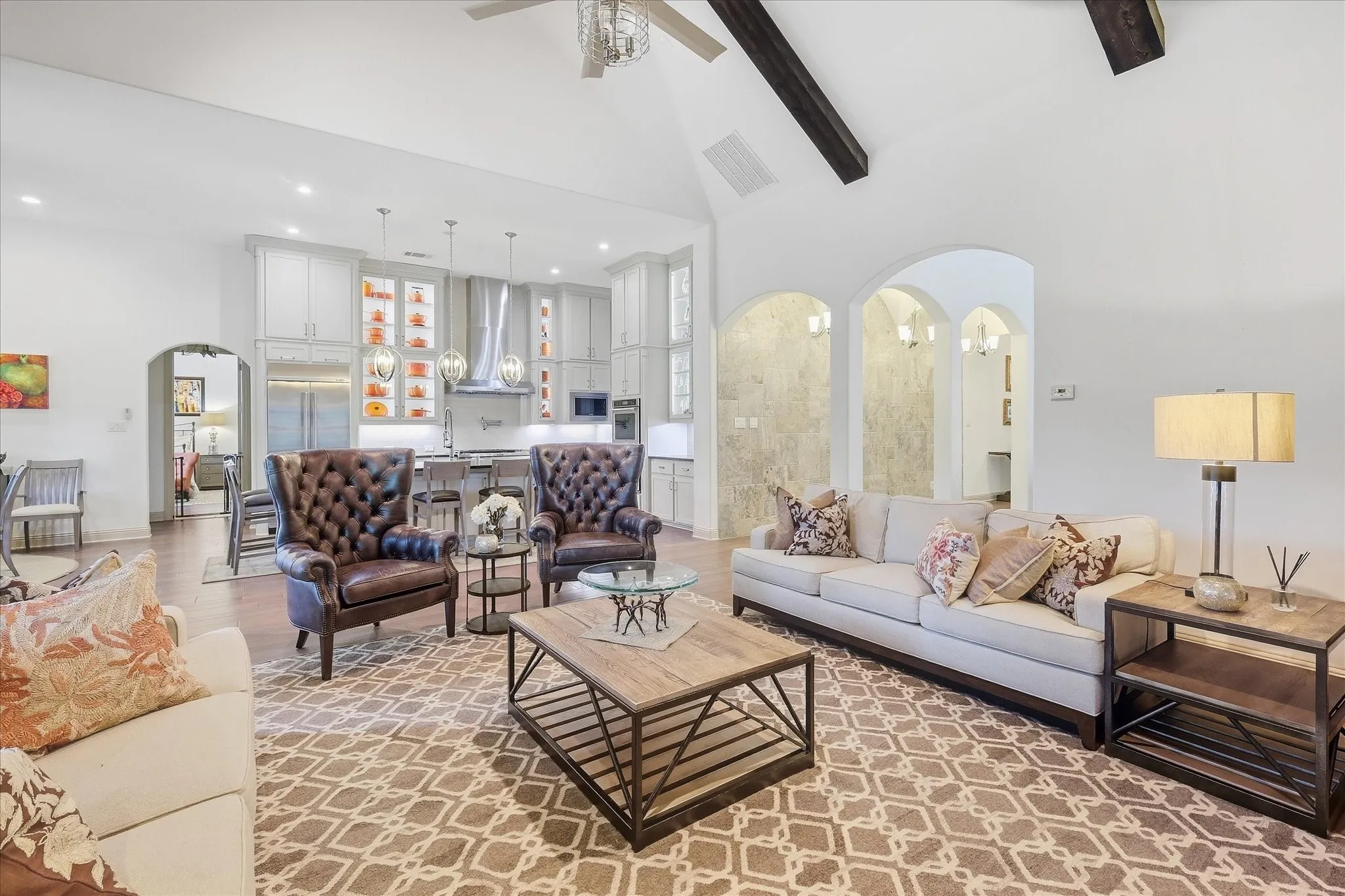 Vaulted ceiling with exposed wood beams, recessed lighting, arched doorways, and wood flooring