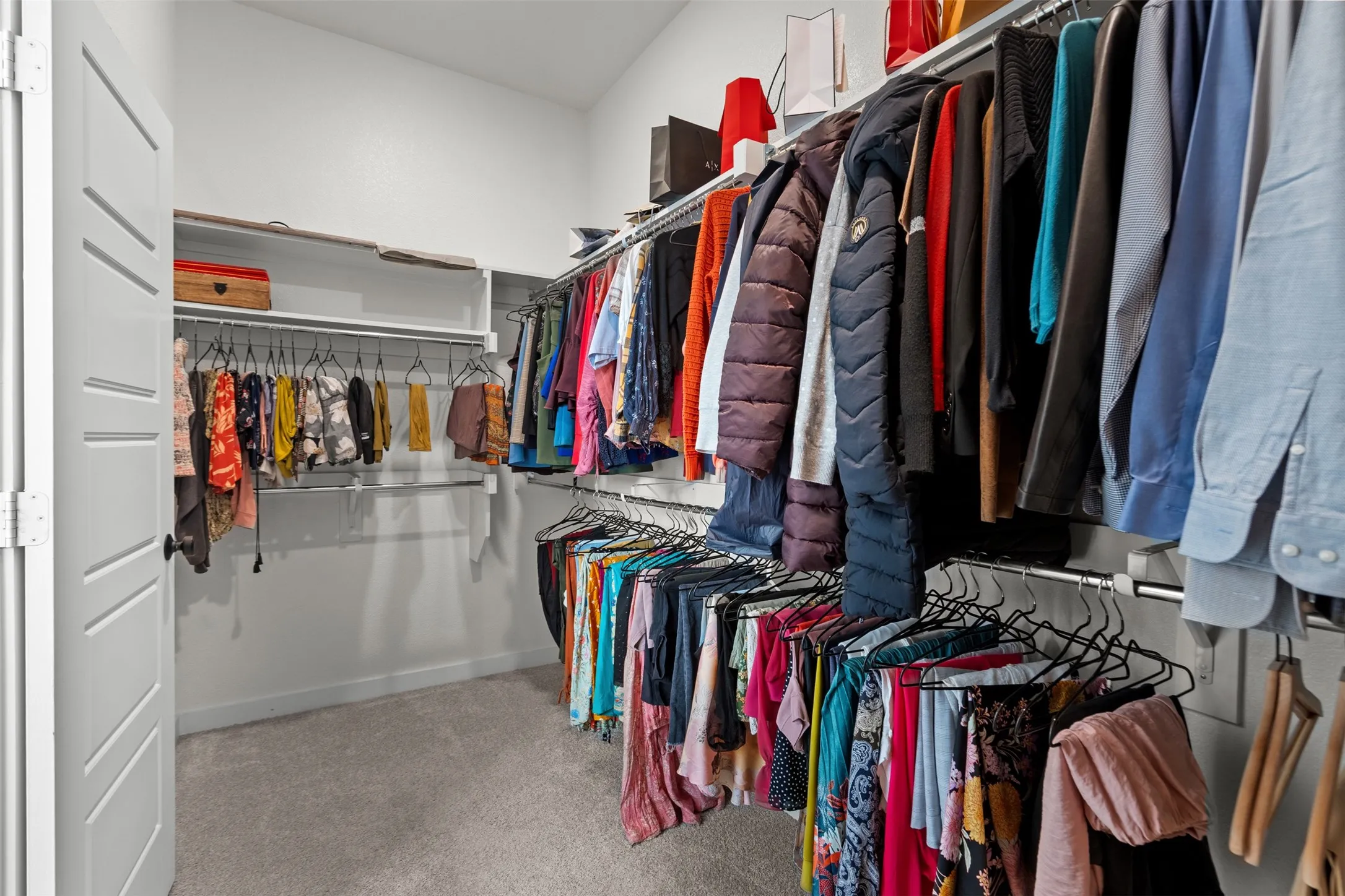 Custom closet system featuring multiple hanging rods and integrated shelving