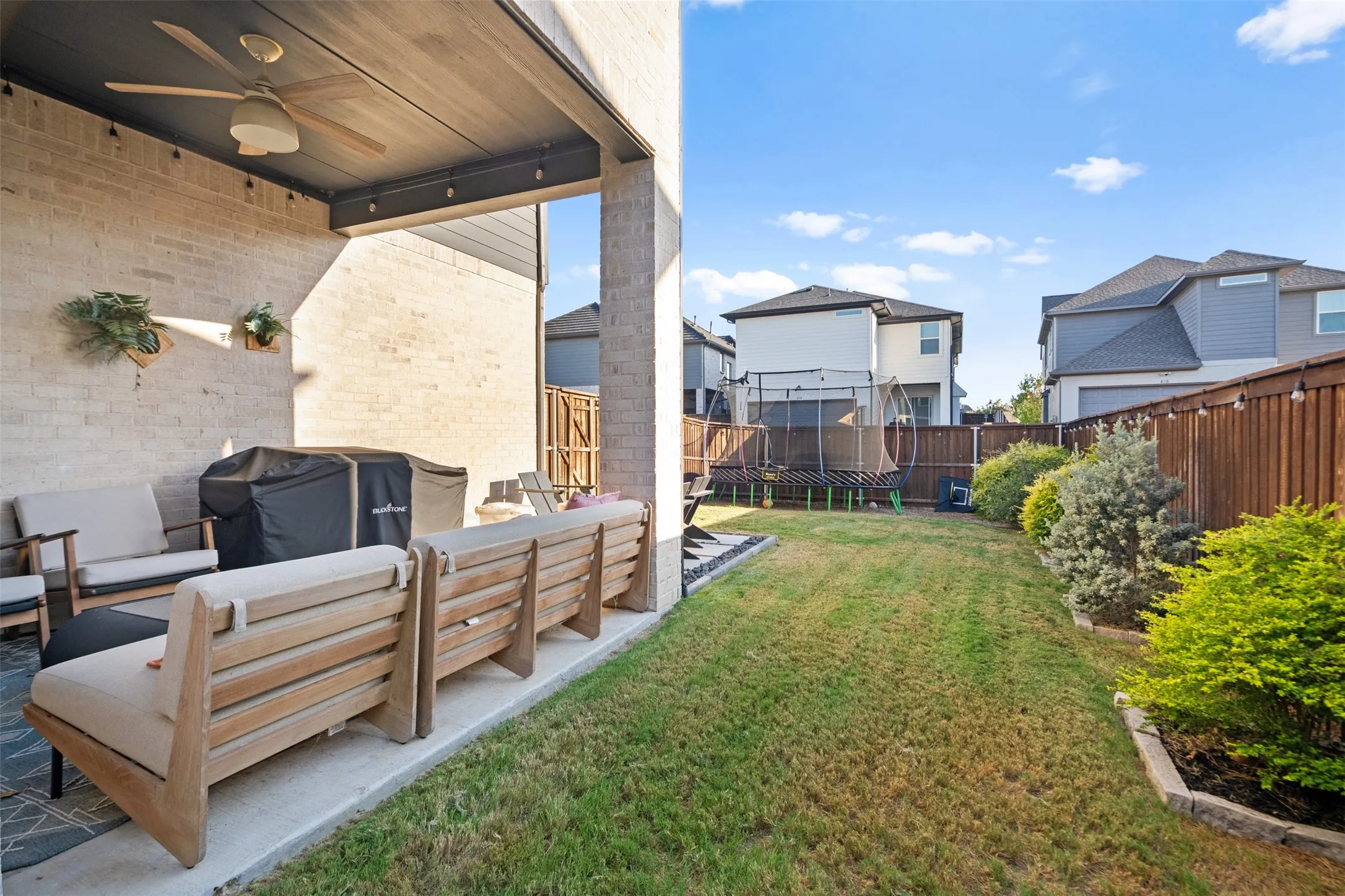 Covered patio with brick wall, ceiling fan, and recessed lighting