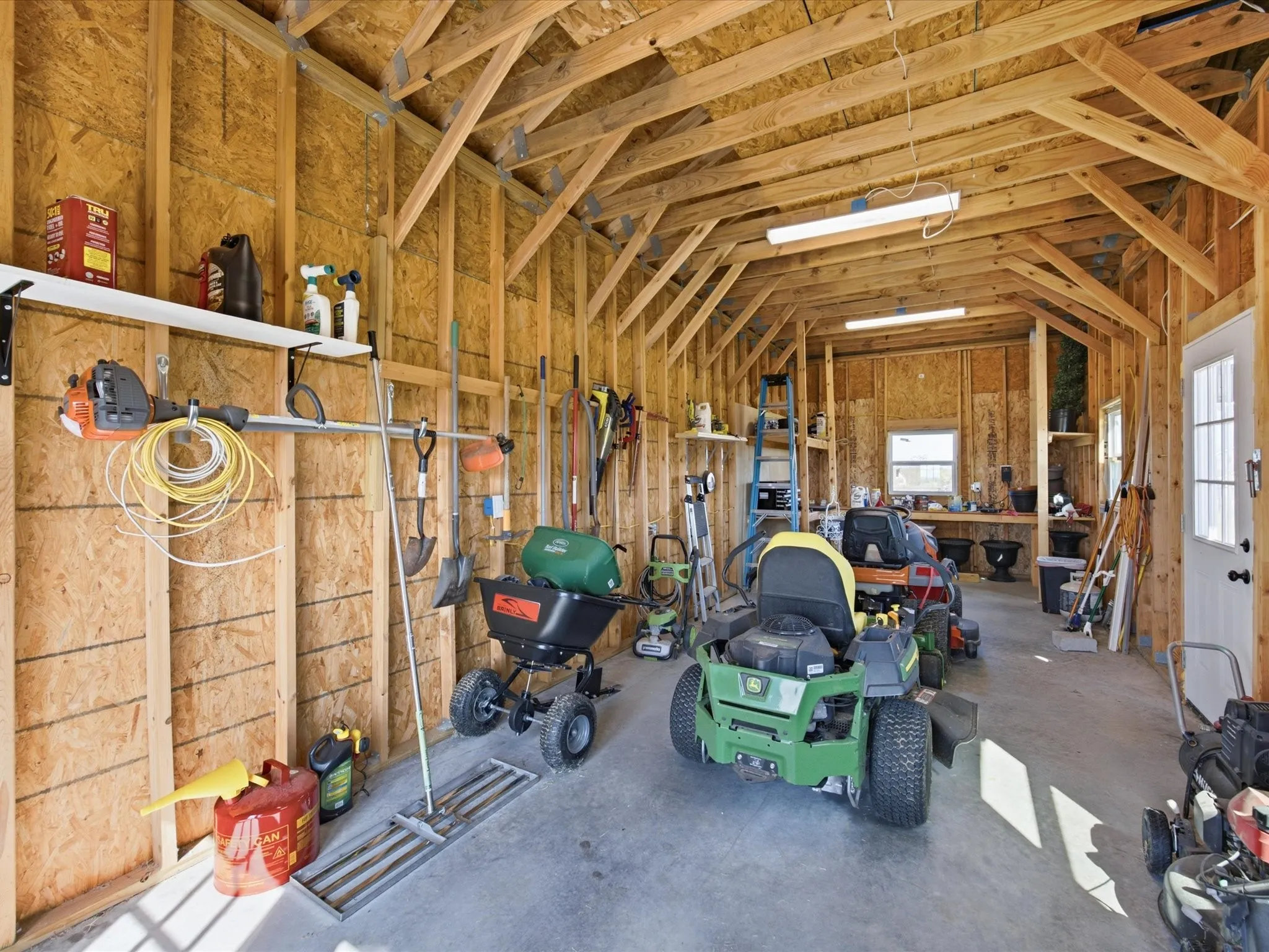 Spacious, fully equipped workshop with electricity, ample storage, built-in shelving, and plenty of room for equipment, tools, and projects.