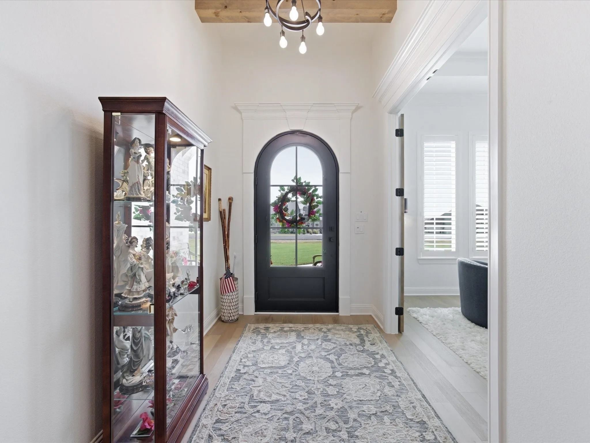 An arched front door floods the foyer with natural light.