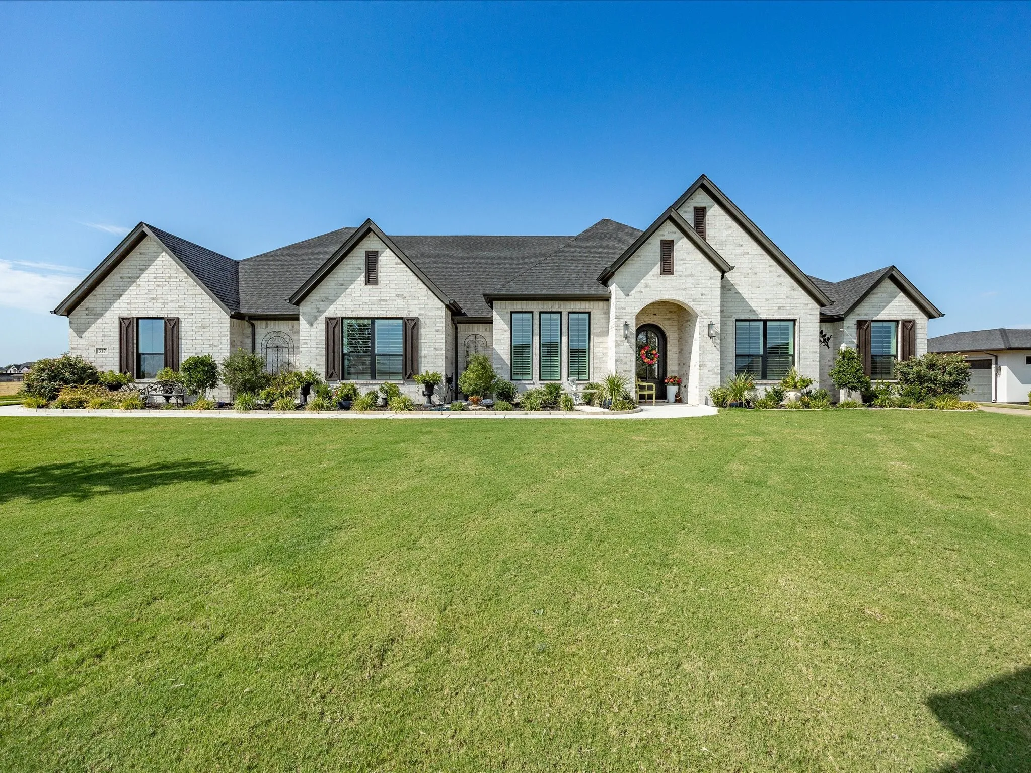 Meticulously landscaped front yard creates a warm and inviting welcoming for guests.