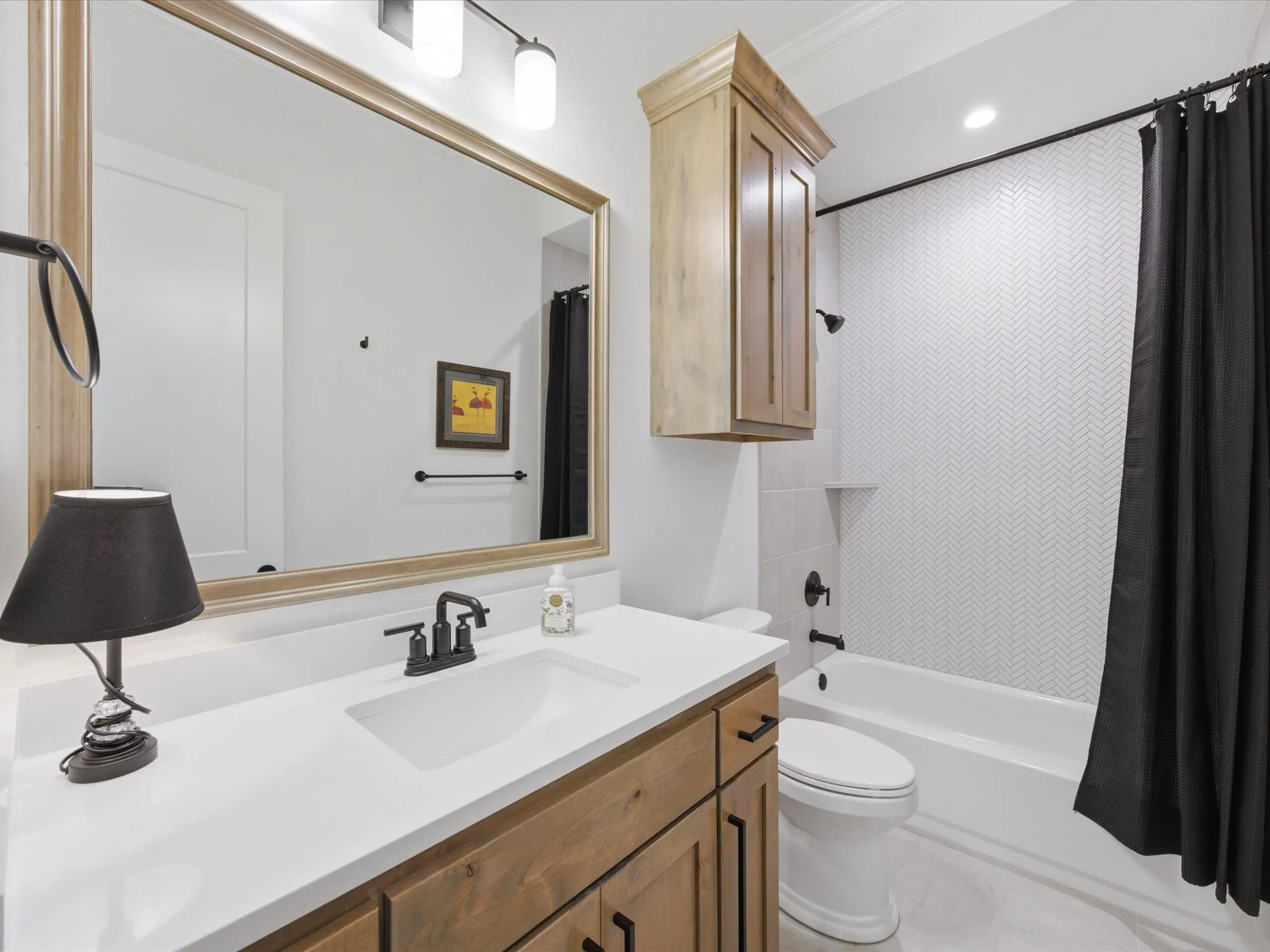Third bathroom has a tub/shower combo with a decorative tile surround.