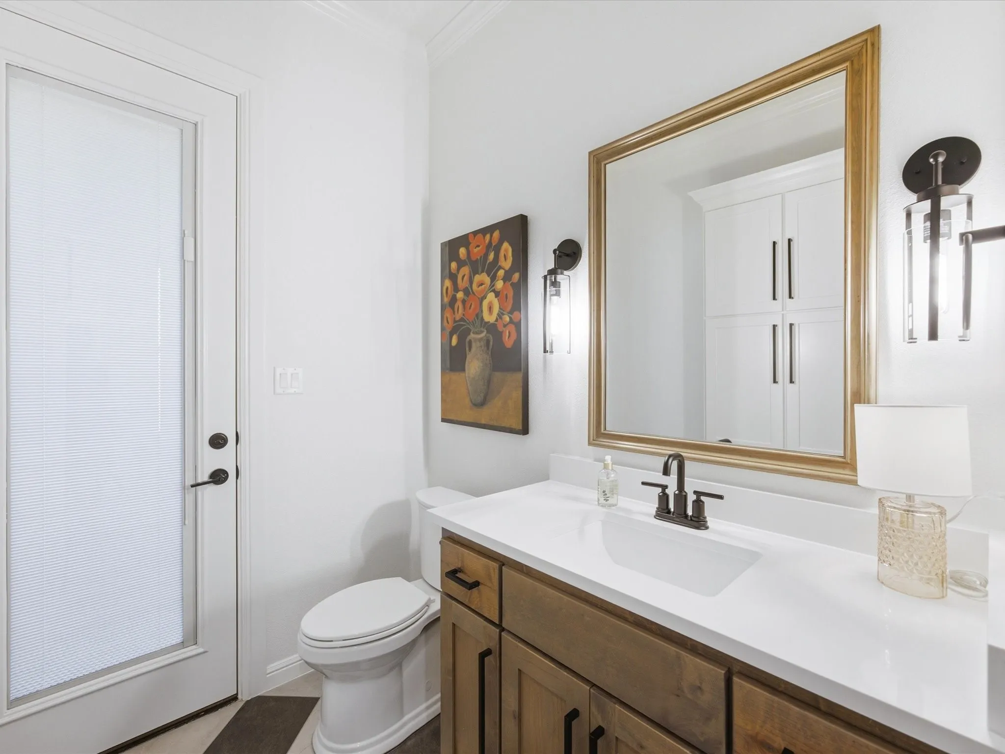 The half bath features checked tile floors and quartz counter-tops.
