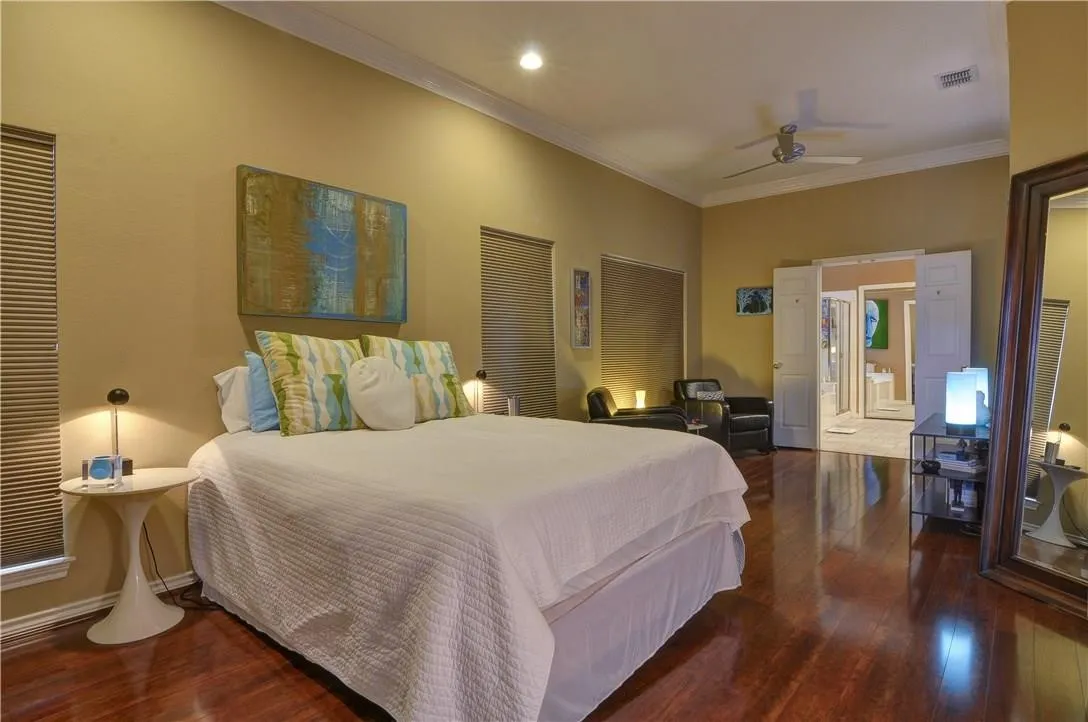High ceilings with crown molding, recessed lighting, wood-finish flooring, ceiling fan, and French doors