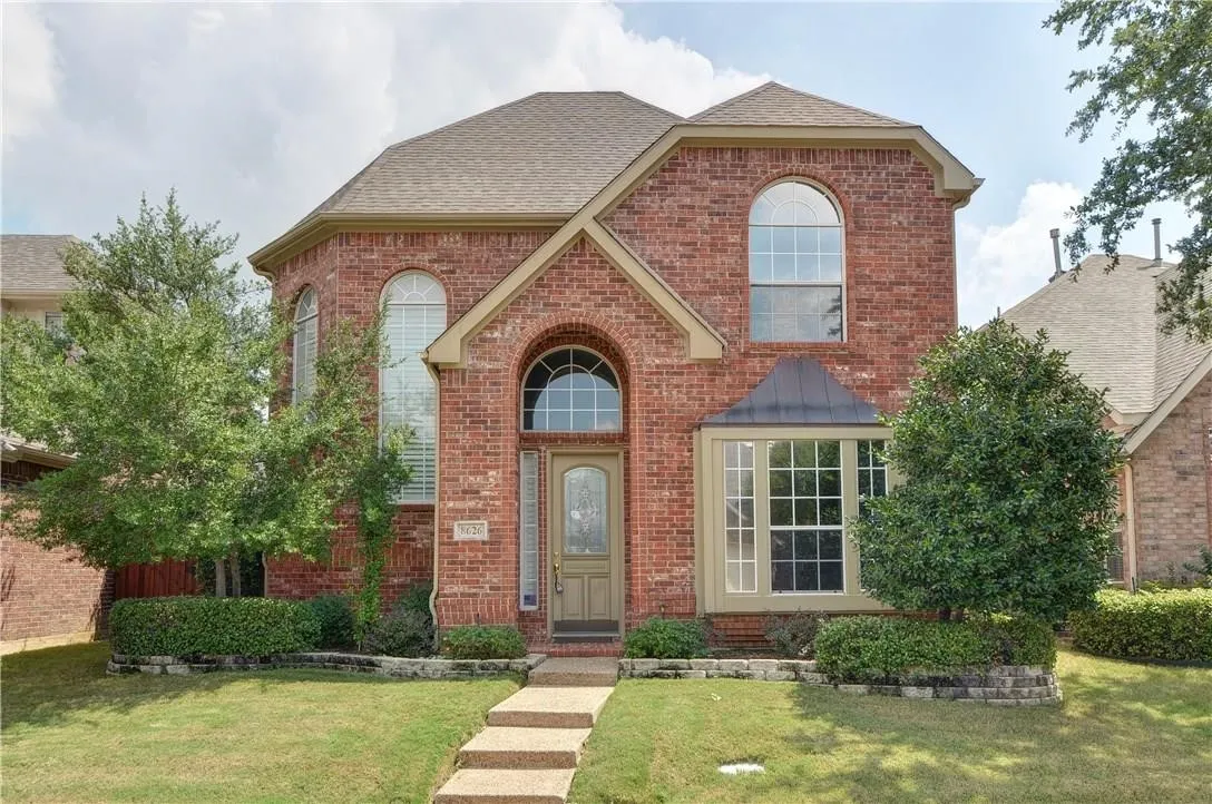 Brick exterior featuring an arched entryway, multiple arched windows, and a bay window