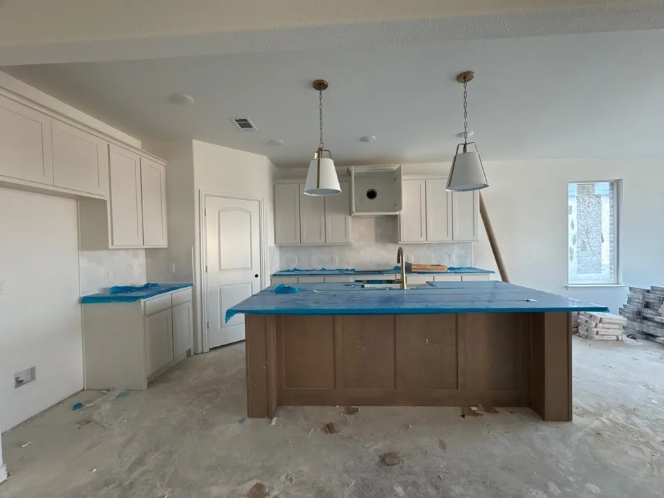 Kitchen featuring white cabinetry, a wood-finish island with a countertop, recessed lighting, and two pendant light fixtures