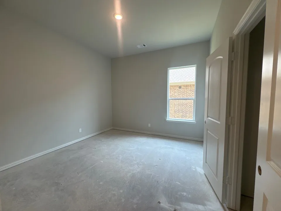 Recessed ceiling lighting, light gray wall paint, white trim, paneled door, and a double-hung window