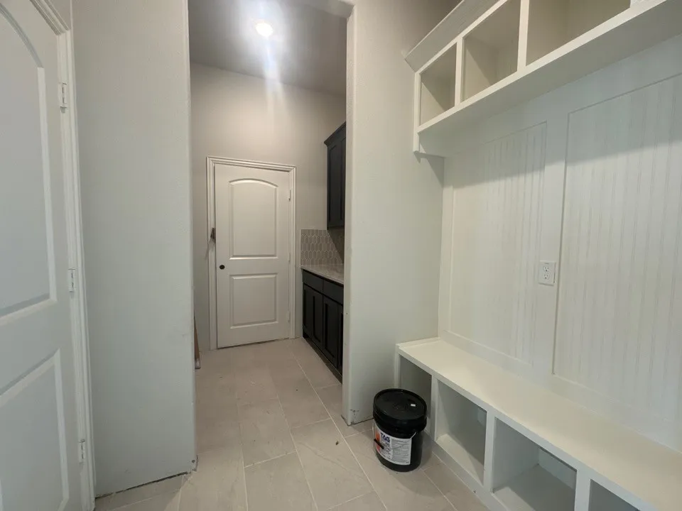 Built-in bench with cubby storage, upper open shelving, and beadboard paneling
