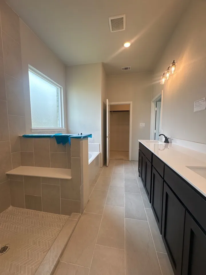 Spacious bathroom featuring a dual vanity, undermount sinks, and a large soaking tub