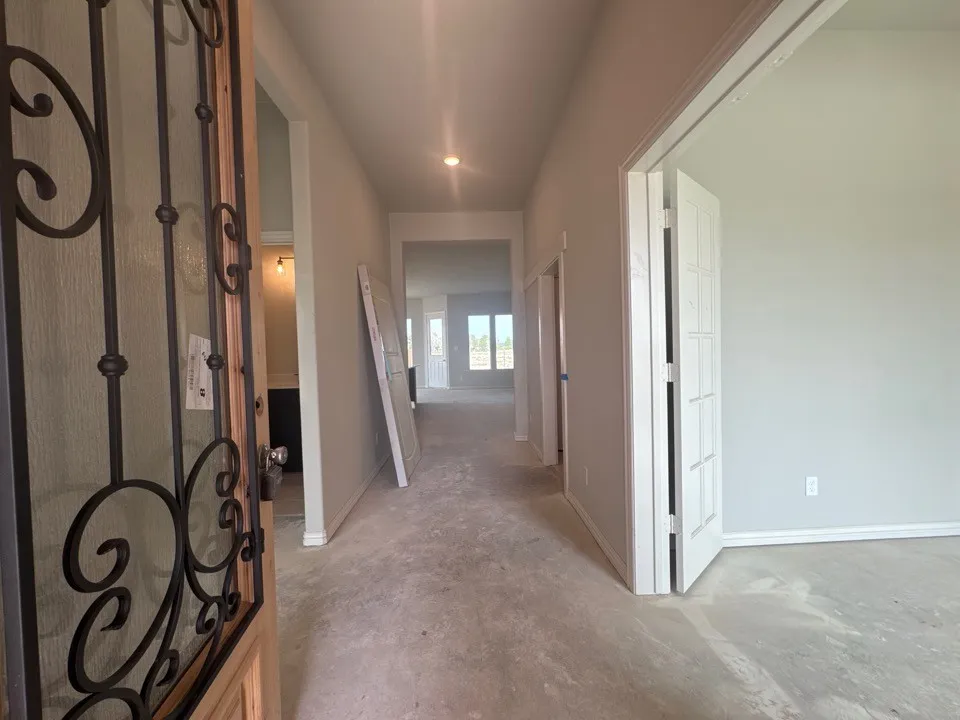 Entryway featuring an ornate wrought iron security door, recessed lighting, and light-toned walls