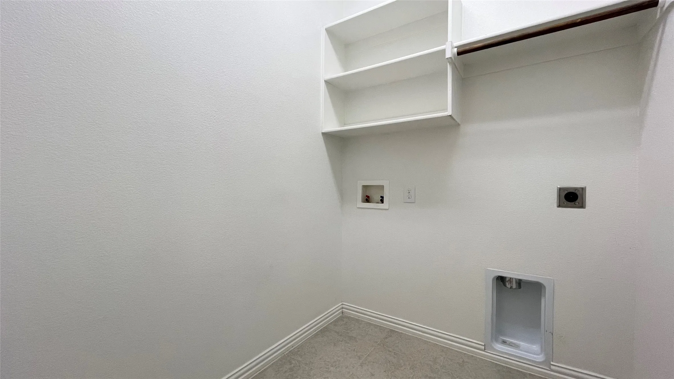 White built-in shelving, integrated clothing rod, and neutral tile flooring
