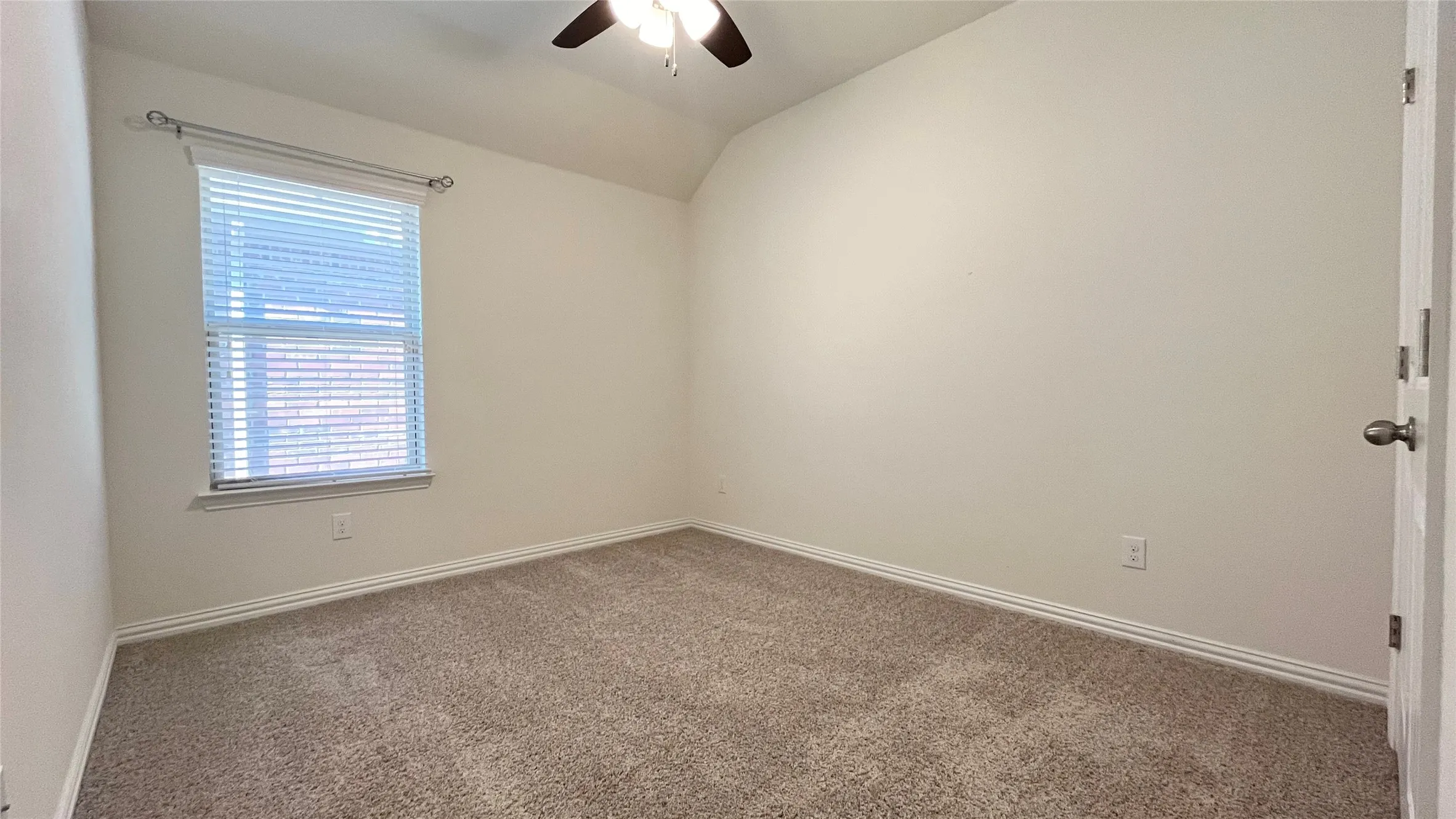 Carpeted room featuring a ceiling fan, a window with blinds, and neutral wall paint