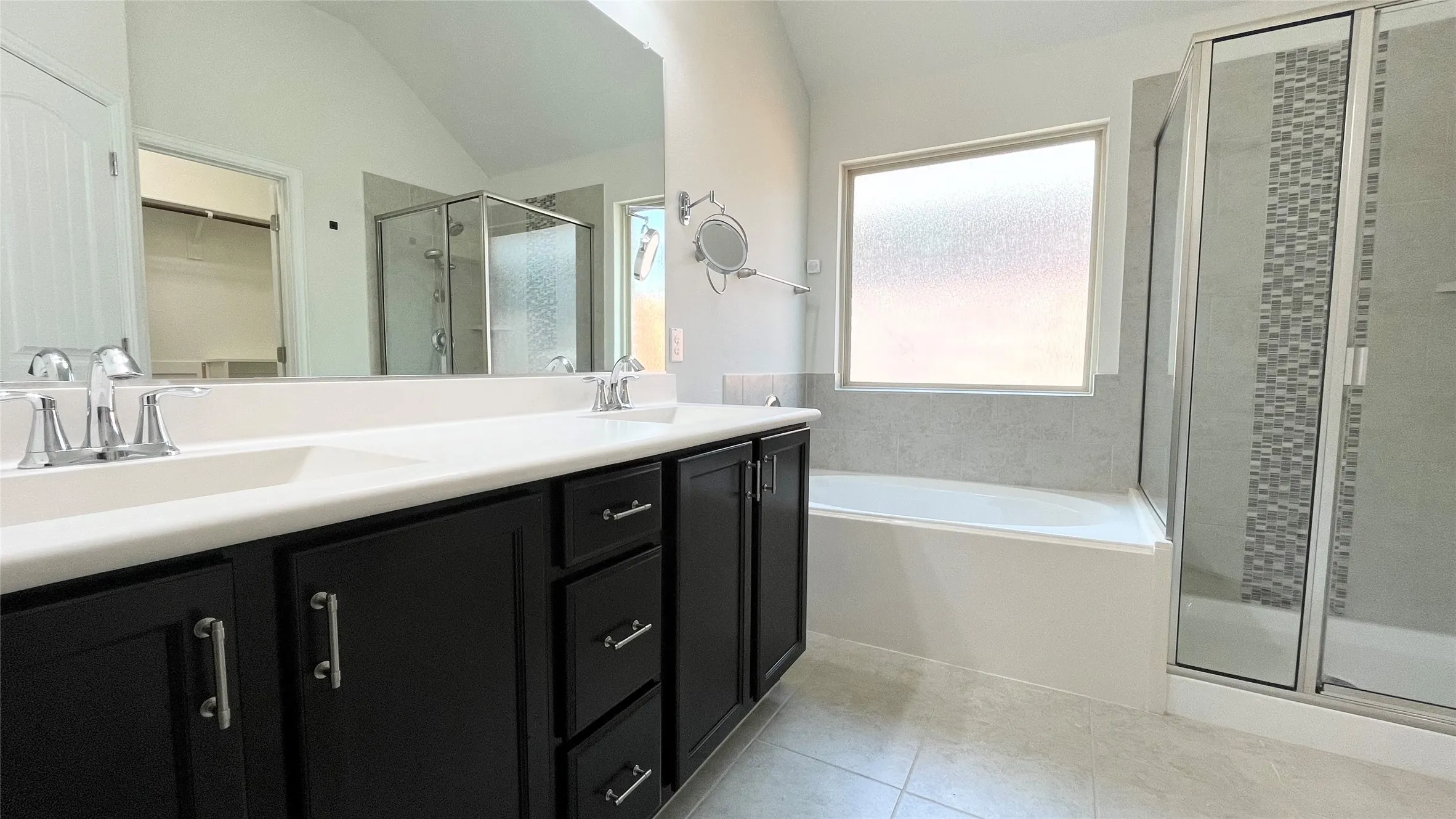 Dual vanity with dark wood-finish cabinetry, white countertop, and chrome fixtures