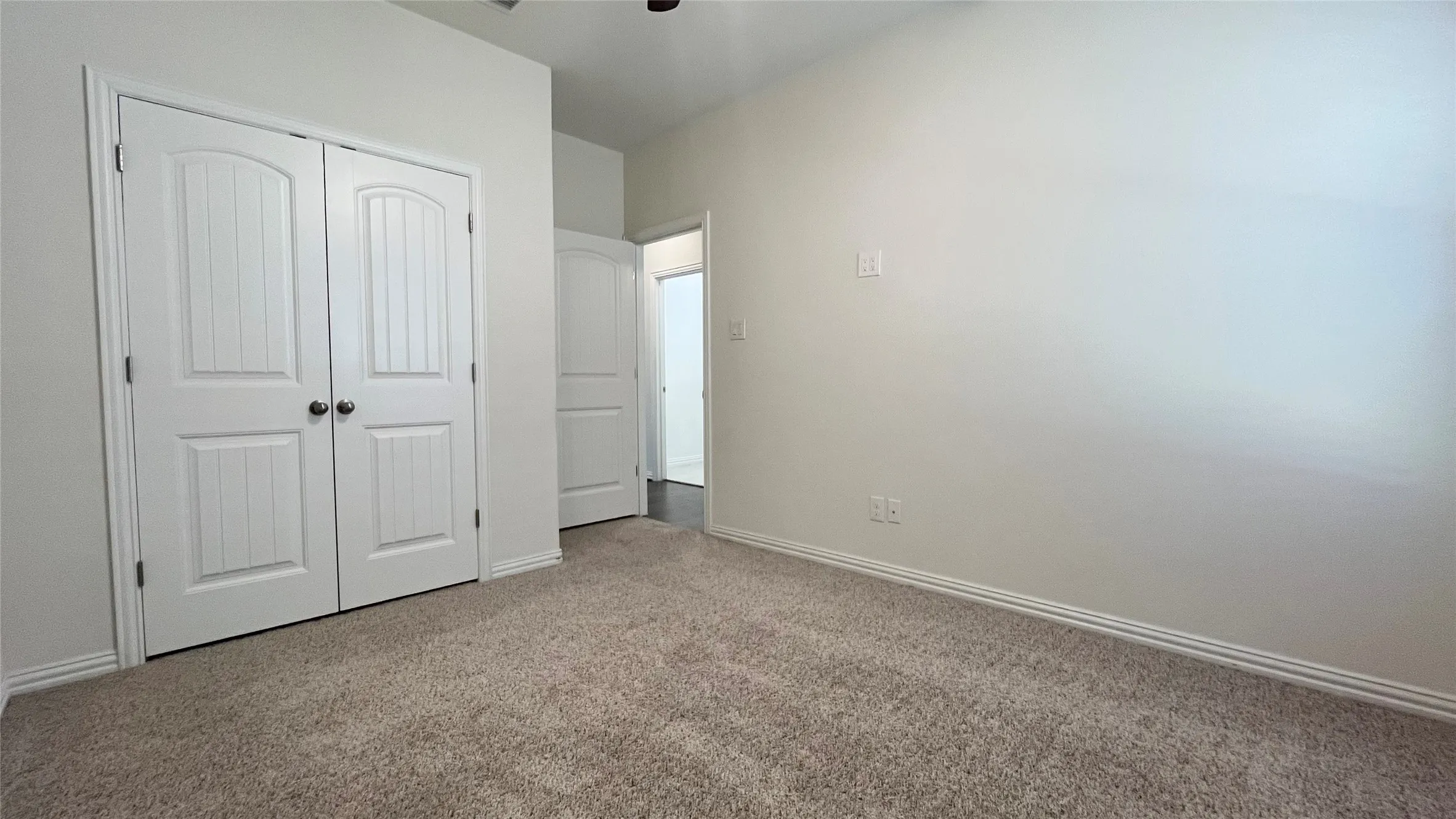 Plush carpeting, white paneled doors, and neutral wall finishes
