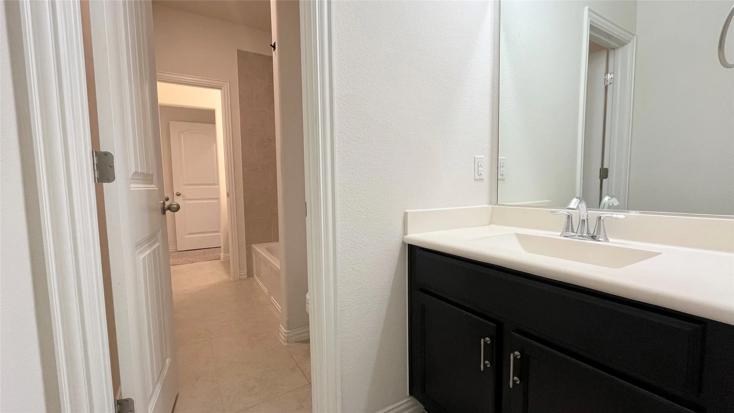 Vanity with an integrated sink, polished chrome faucet, and dark wood-finish cabinetry