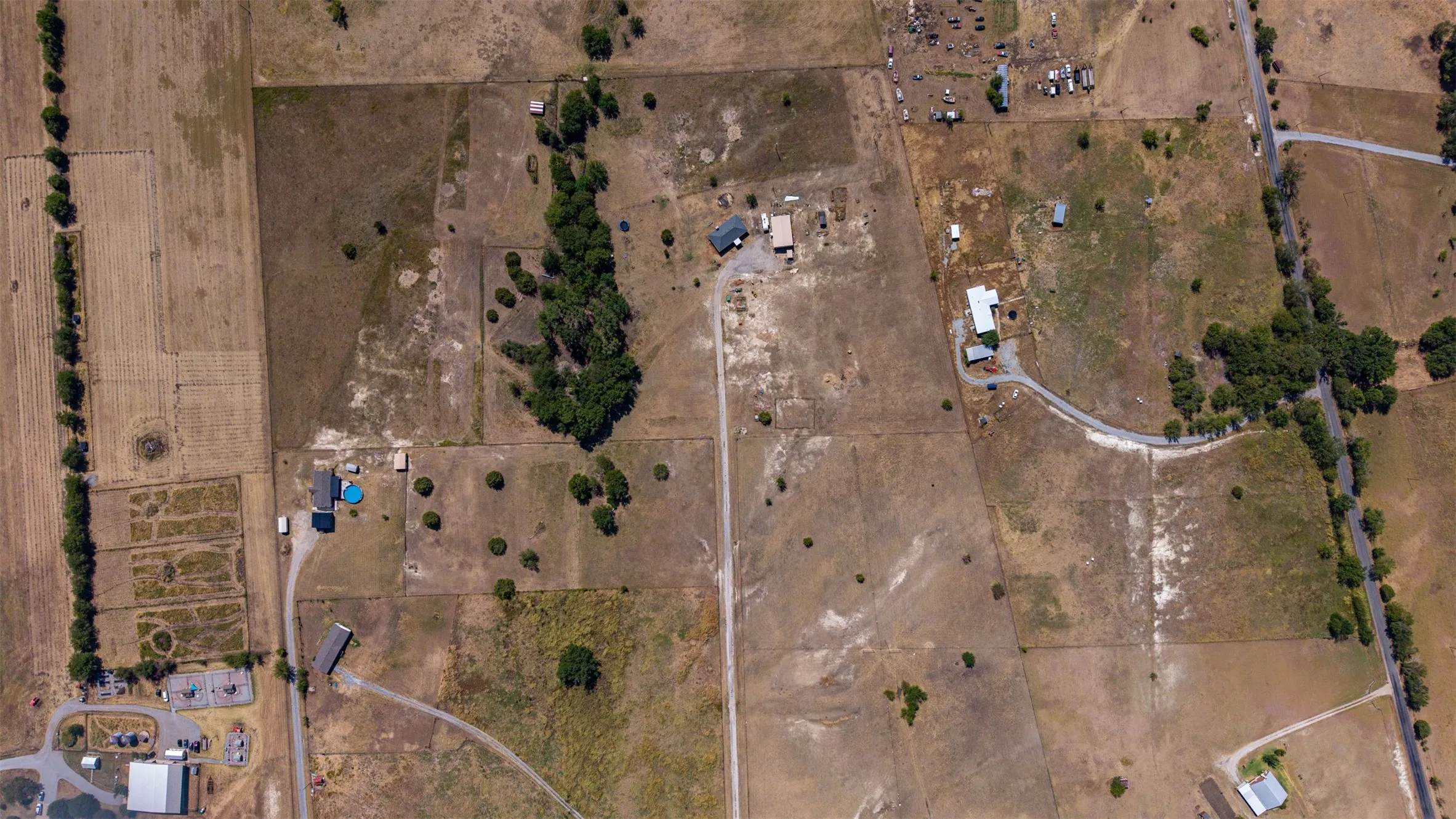 Expansive rural landscape featuring multiple parcels, scattered structures, and established access roads