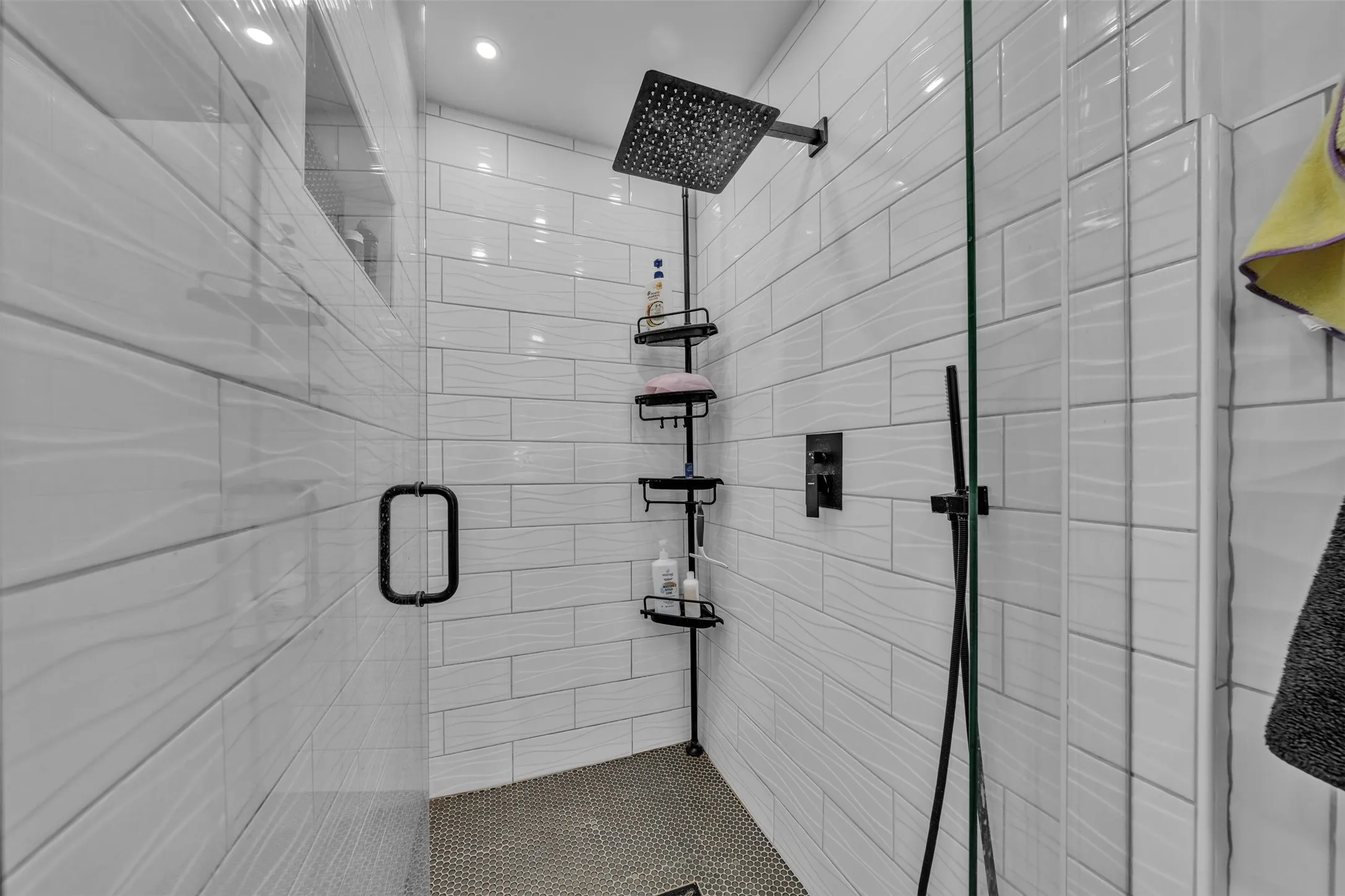 Walk-in shower with clear glass enclosure and matte black hardware