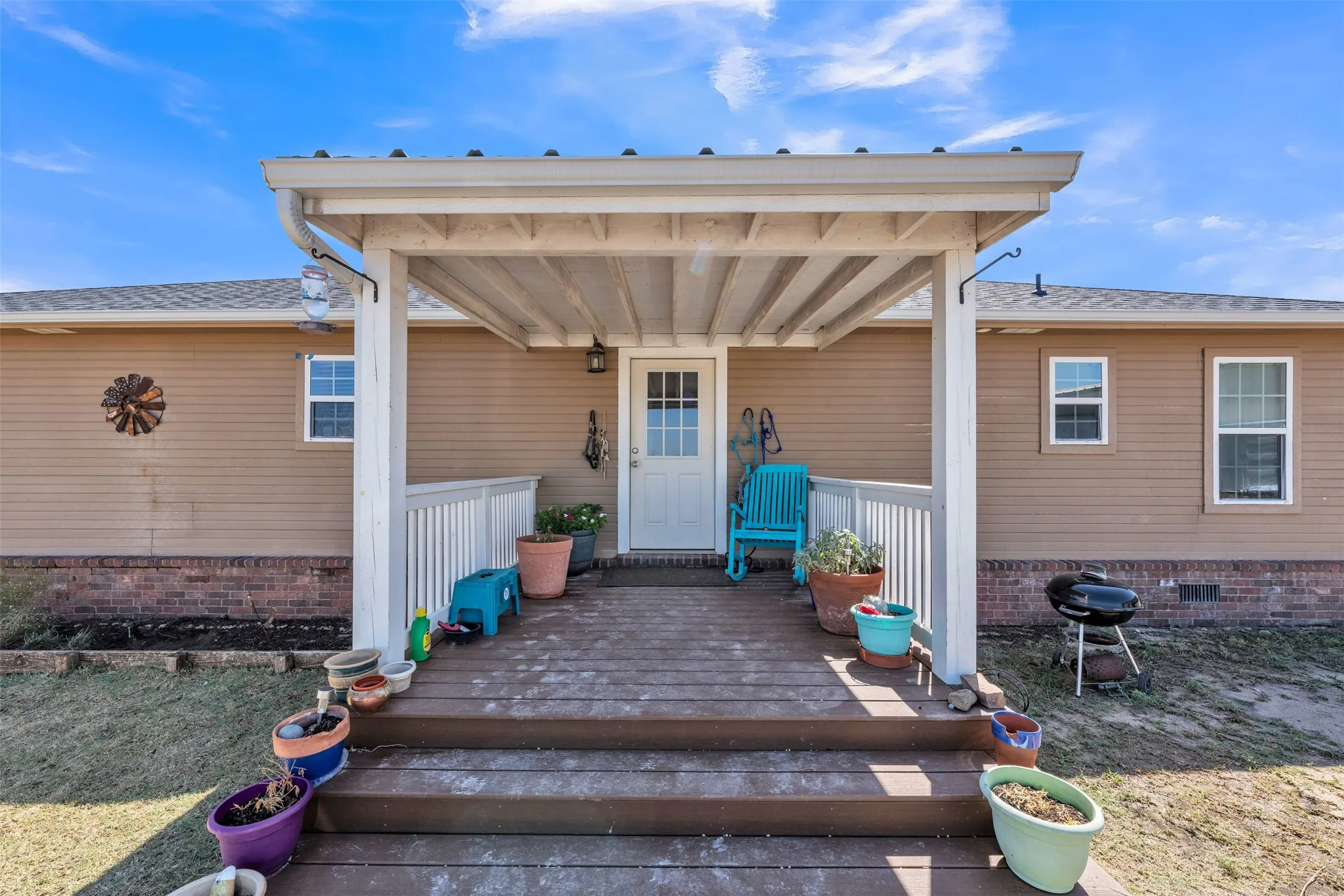 Covered front porch with wood-finish decking and white railing