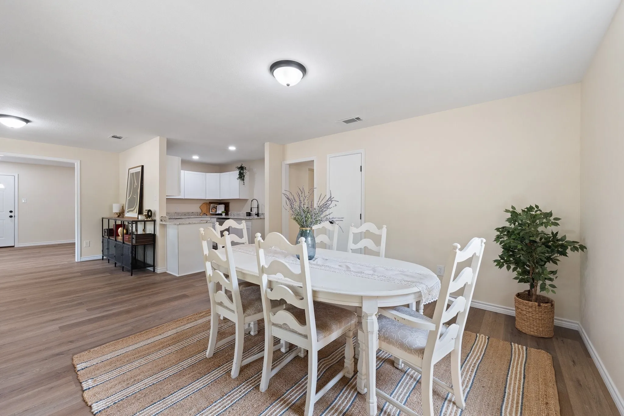 Open-concept living area with wood-finish flooring, recessed lighting, and a neutral color palette