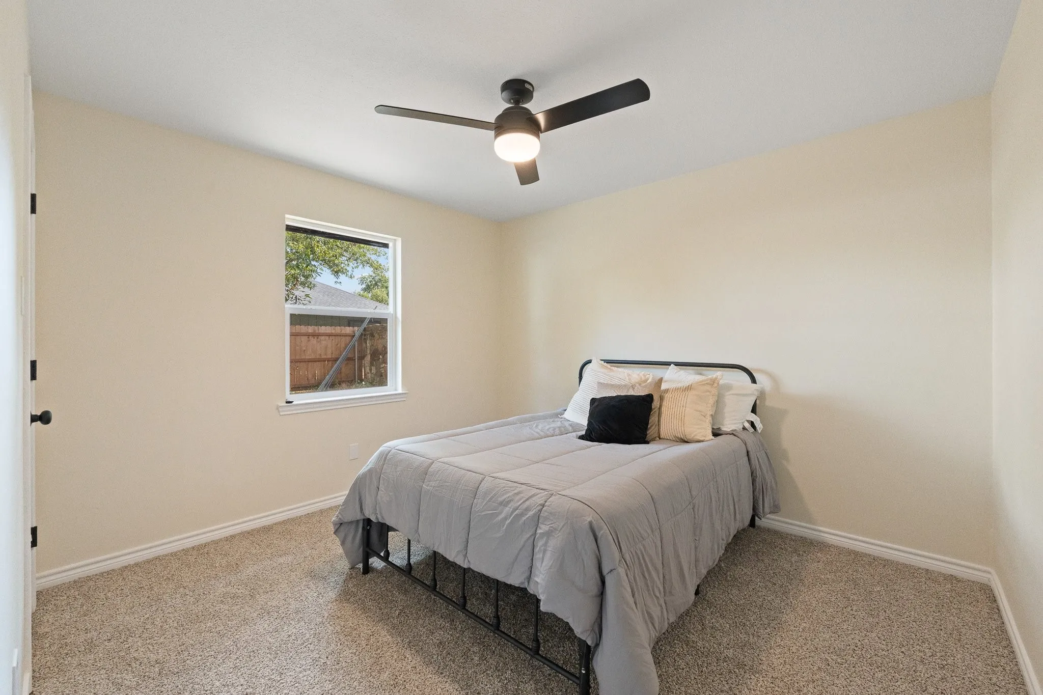Carpeted flooring, single window, ceiling fan with light fixture, and neutral wall paint