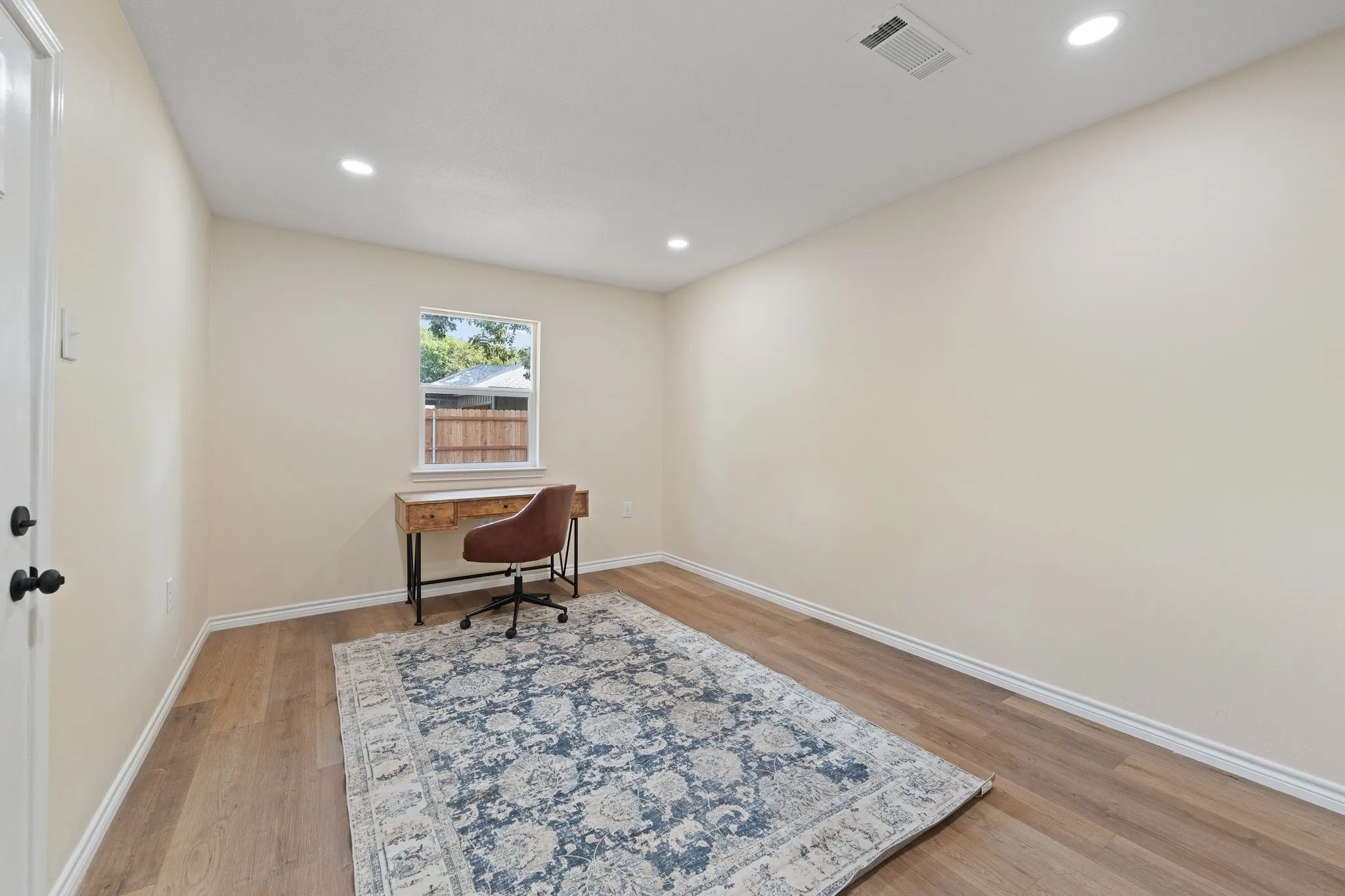 Recessed ceiling lighting with a window and wood-finish flooring