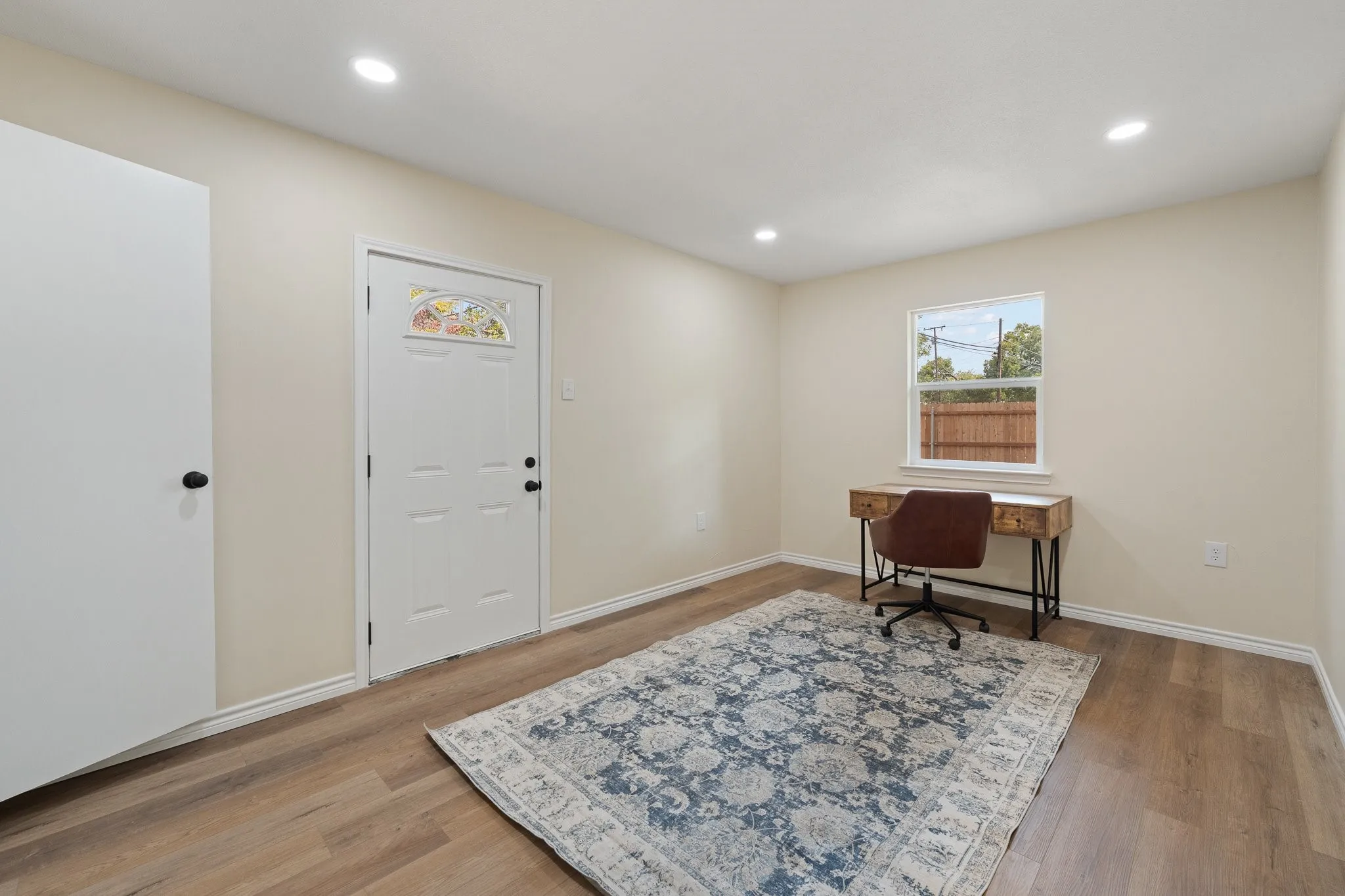 Recessed lighting, wood-finish flooring, and light-toned walls