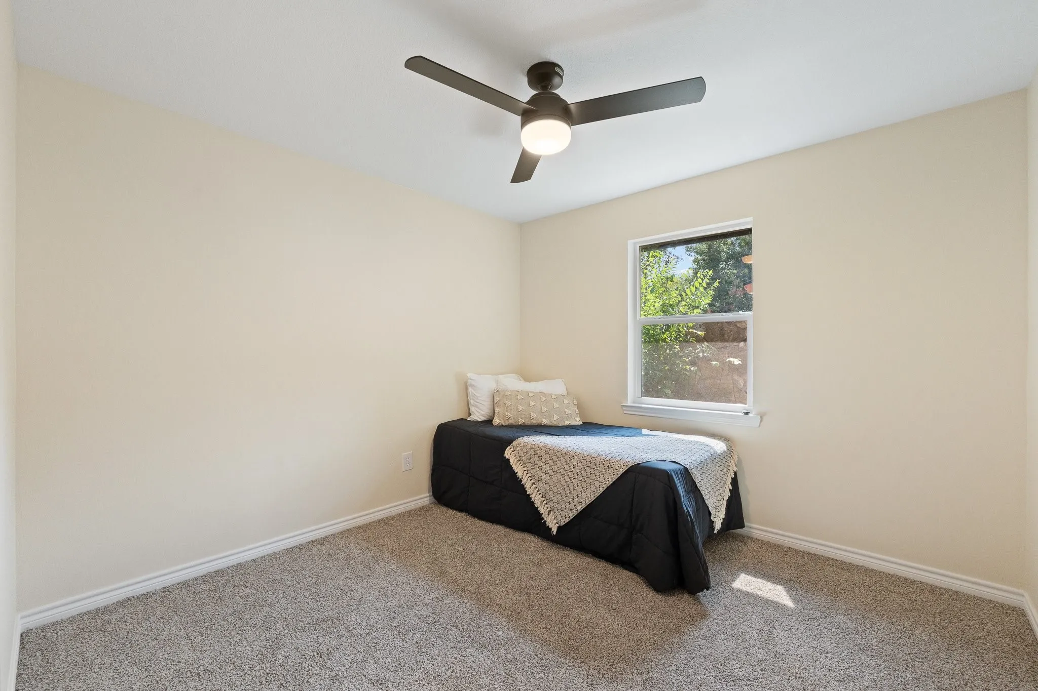 Recessed window with white trim, ceiling fan with integrated lighting, and neutral-toned wall finish