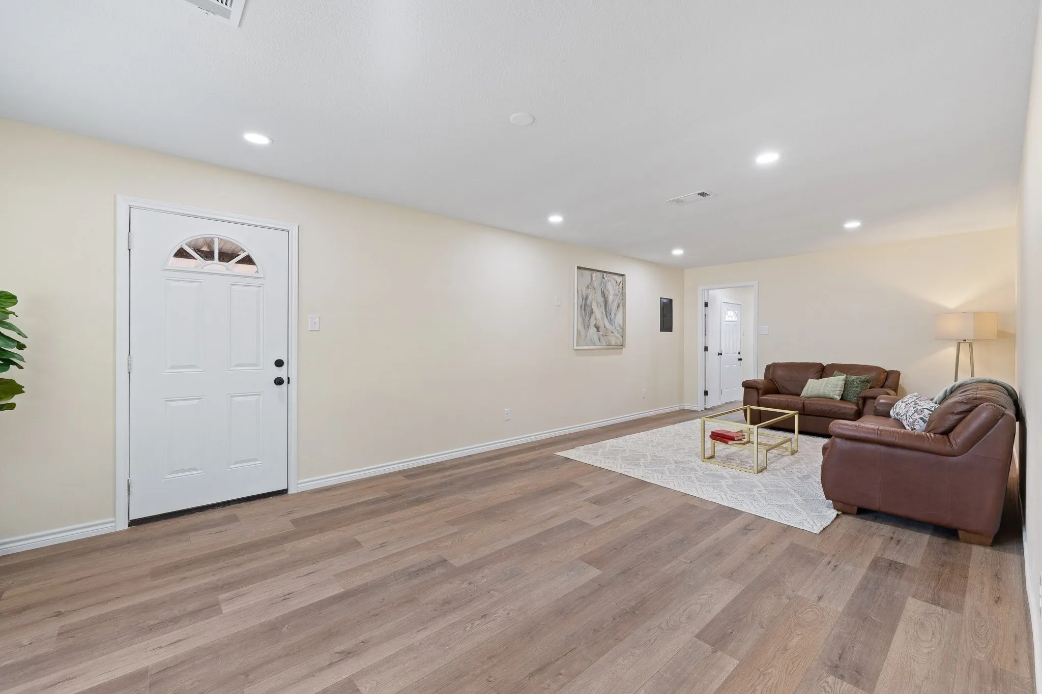 Recessed lighting throughout, wood-finish flooring, light-toned wall paint, and white trim