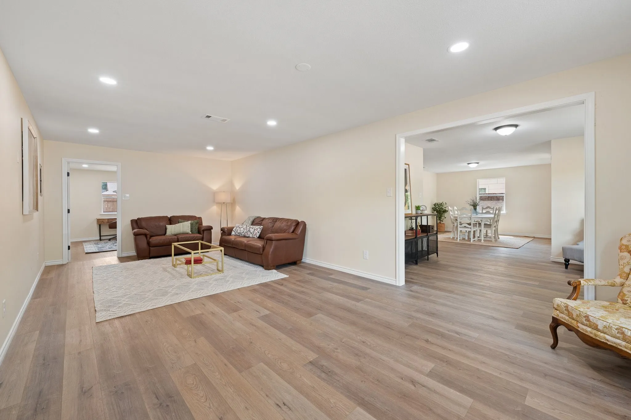 Recessed lighting illuminates wood-finish flooring and neutral wall tones