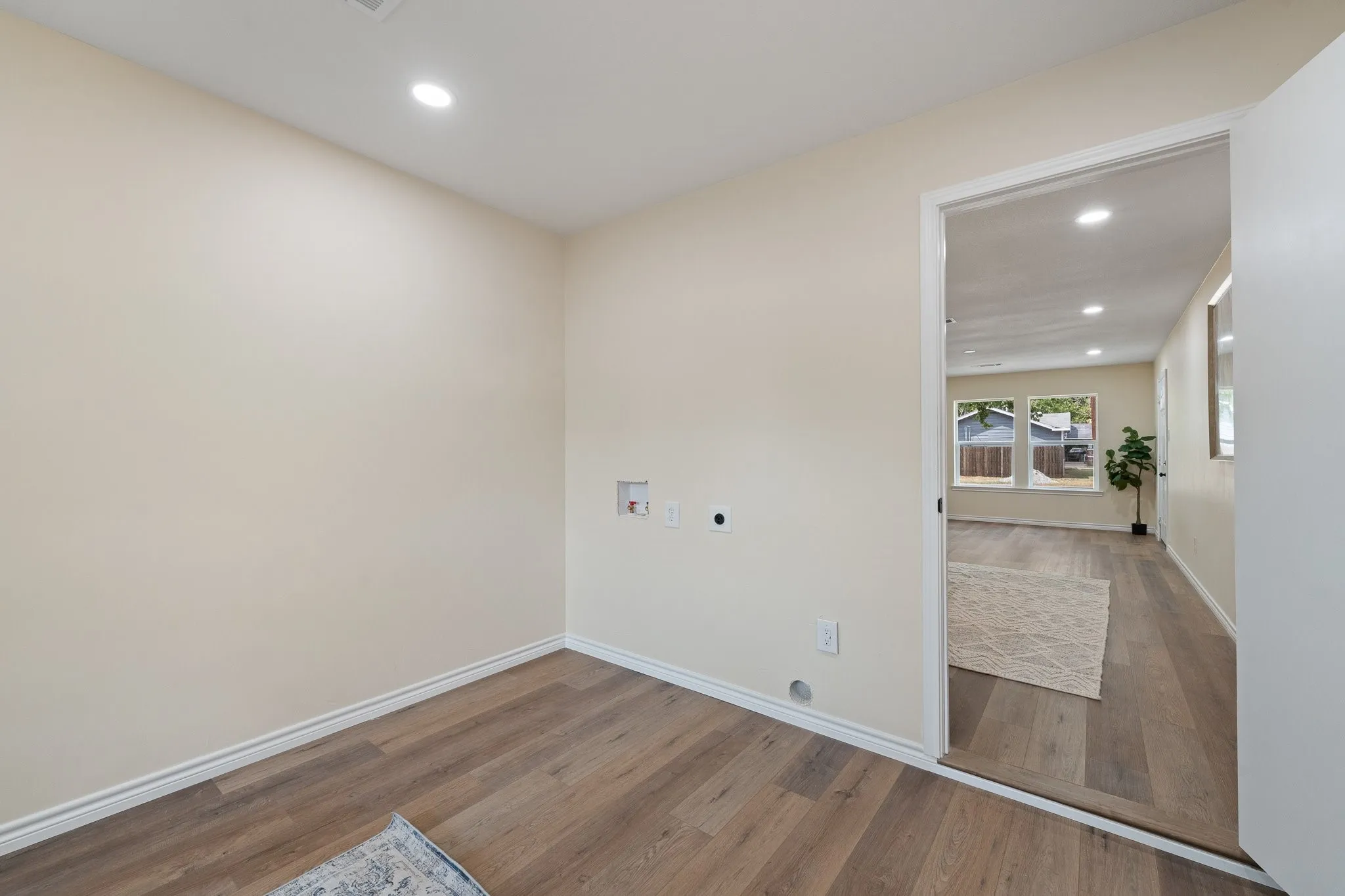 Recessed lighting, wood-finish flooring, and light-toned walls
