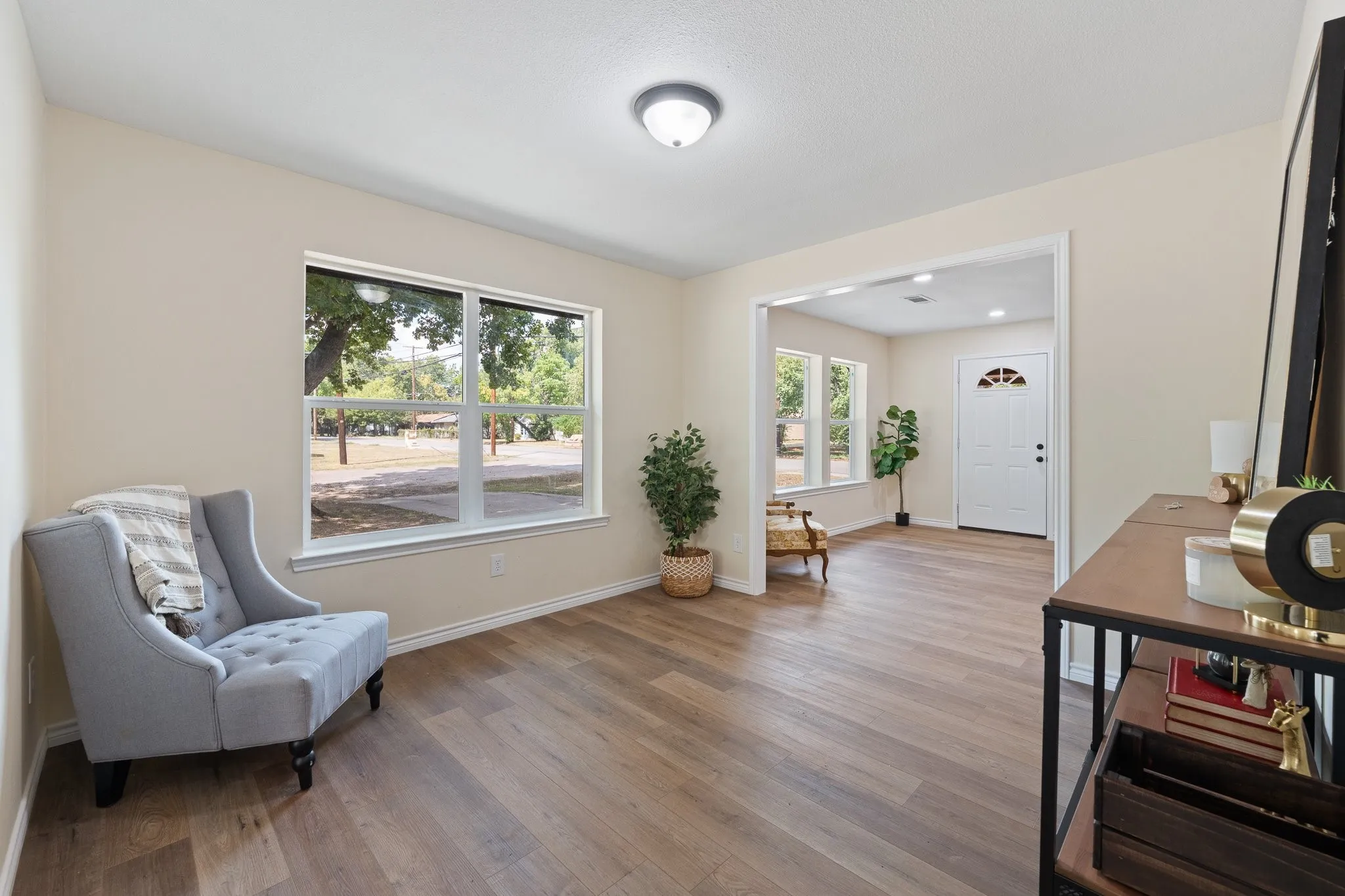 Recessed lighting, wood-finish flooring, light-colored walls, and a white framed window