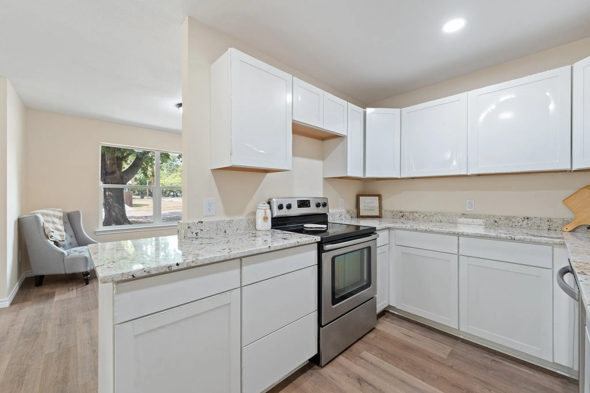 Kitchen featuring white cabinetry, stainless steel range, and light-toned countertops