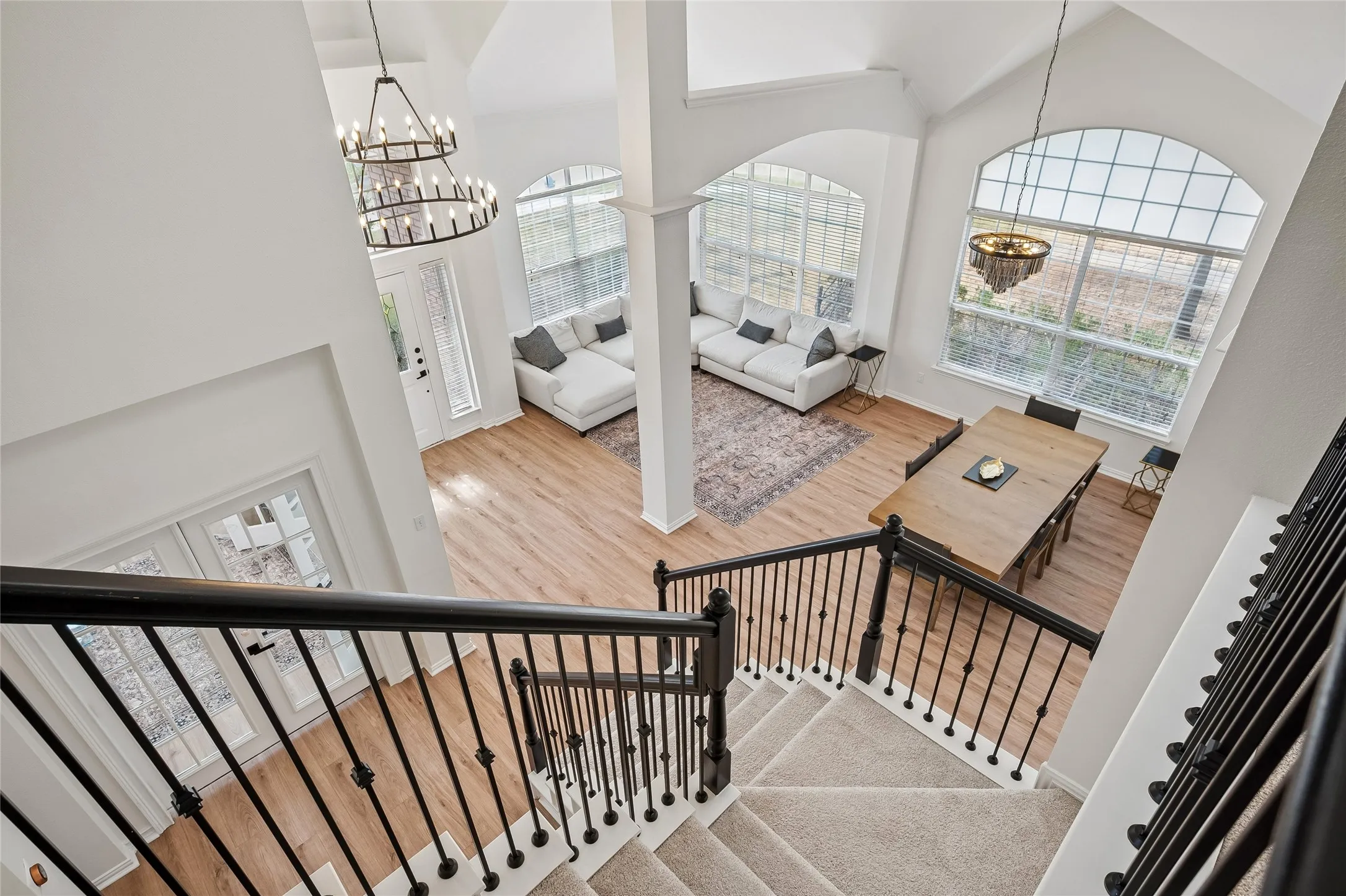 Two-story vaulted ceilings, wood-finish flooring, and large arched windows