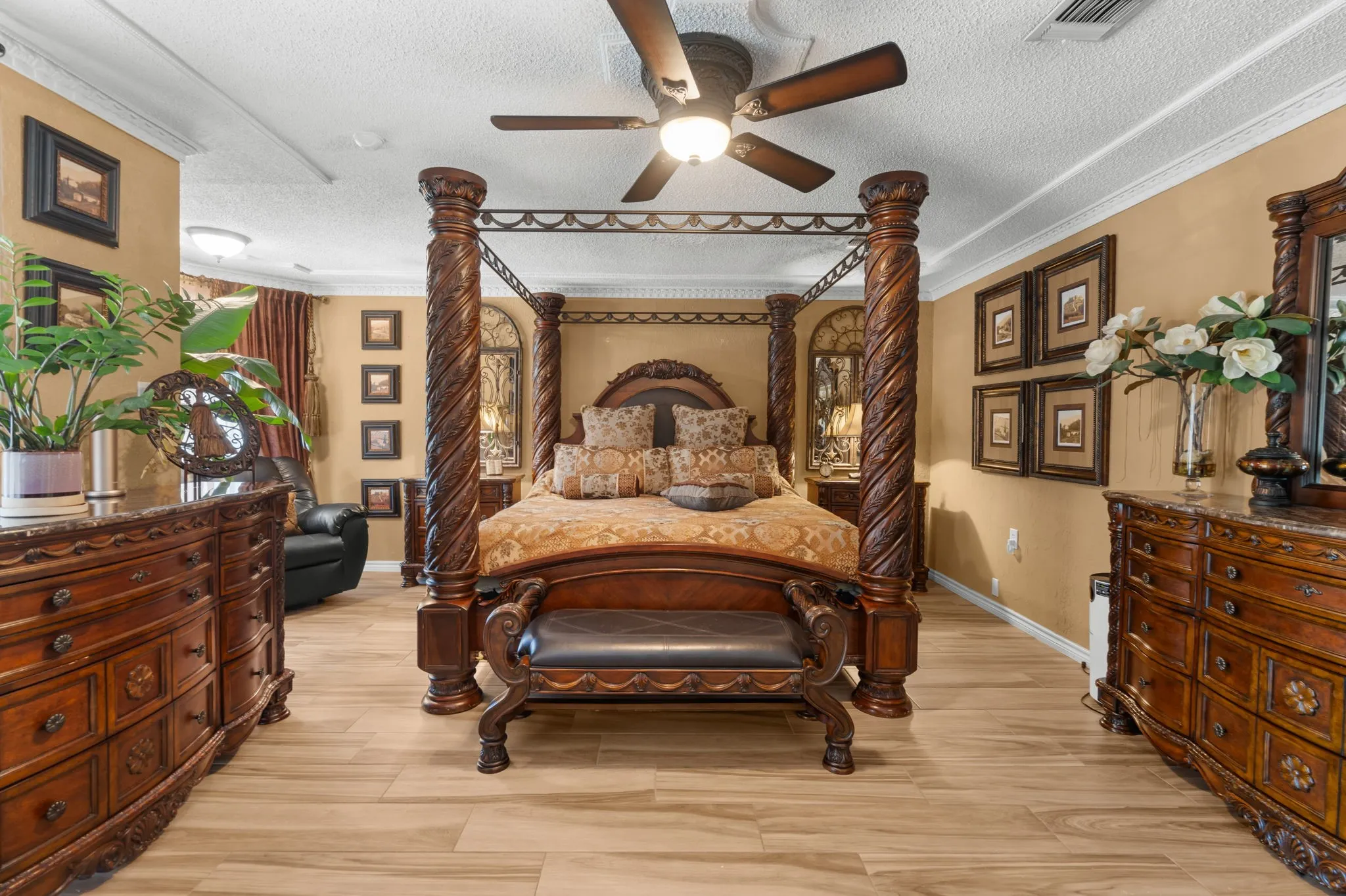 Wood-finish flooring throughout, ceiling fan with integrated lighting, crown molding, and built-in dresser with a marble-look countertop