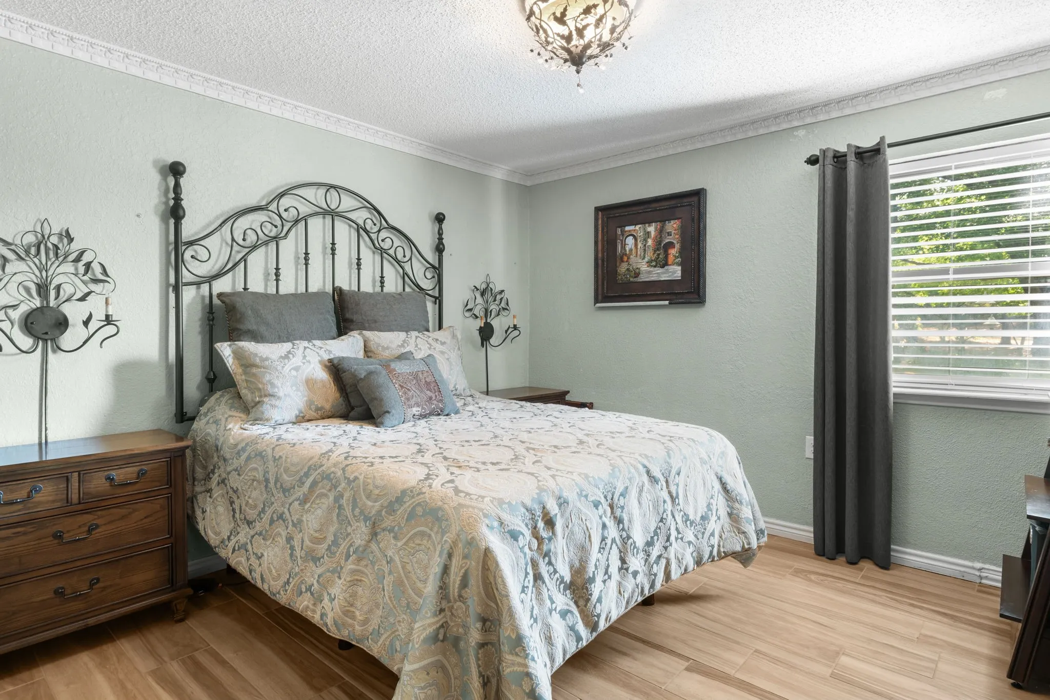 Wood-finish flooring, crown molding, and a window with blinds