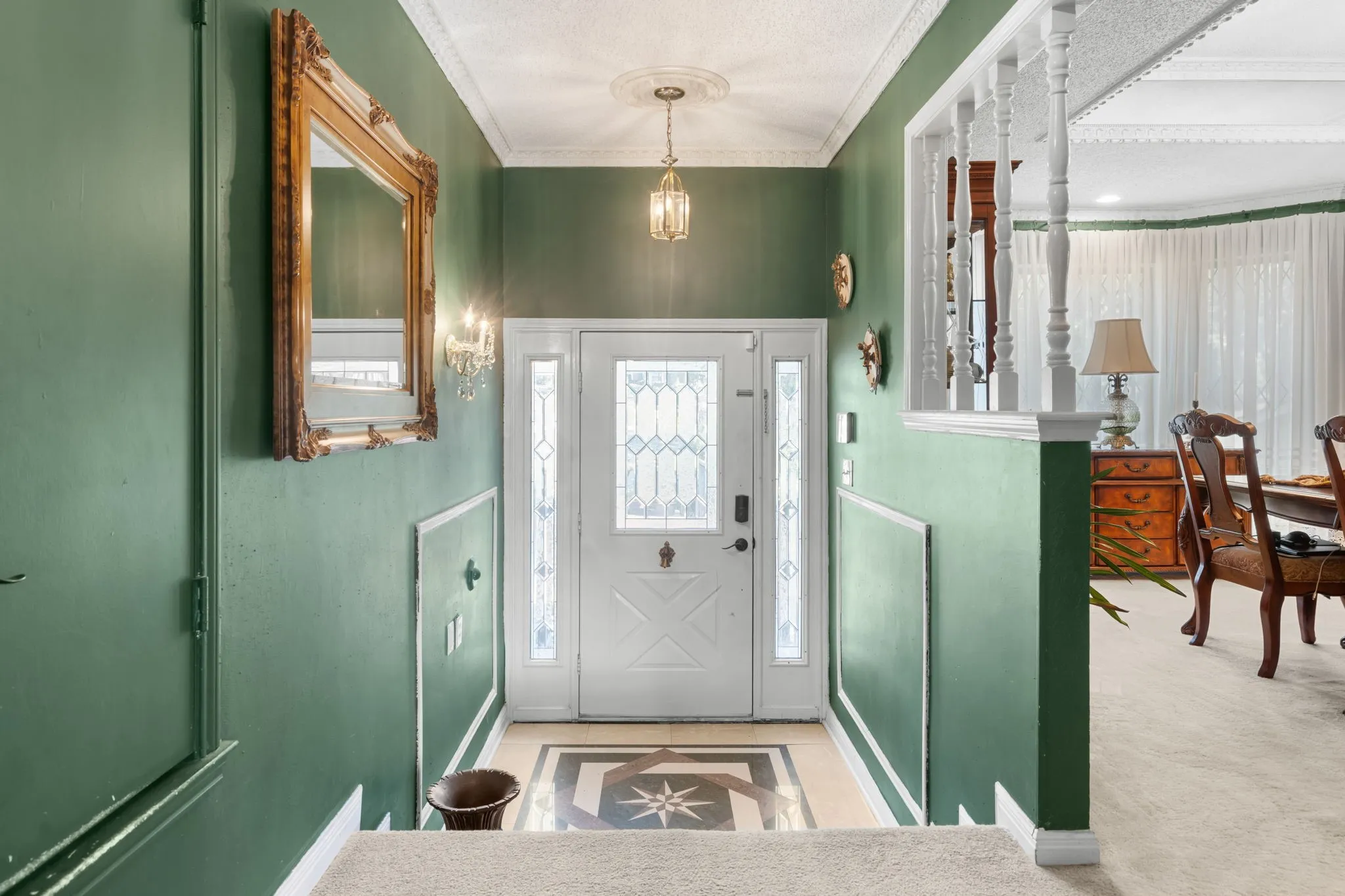 Entryway featuring a decorative transom, leaded glass sidelights, and a patterned tile floor