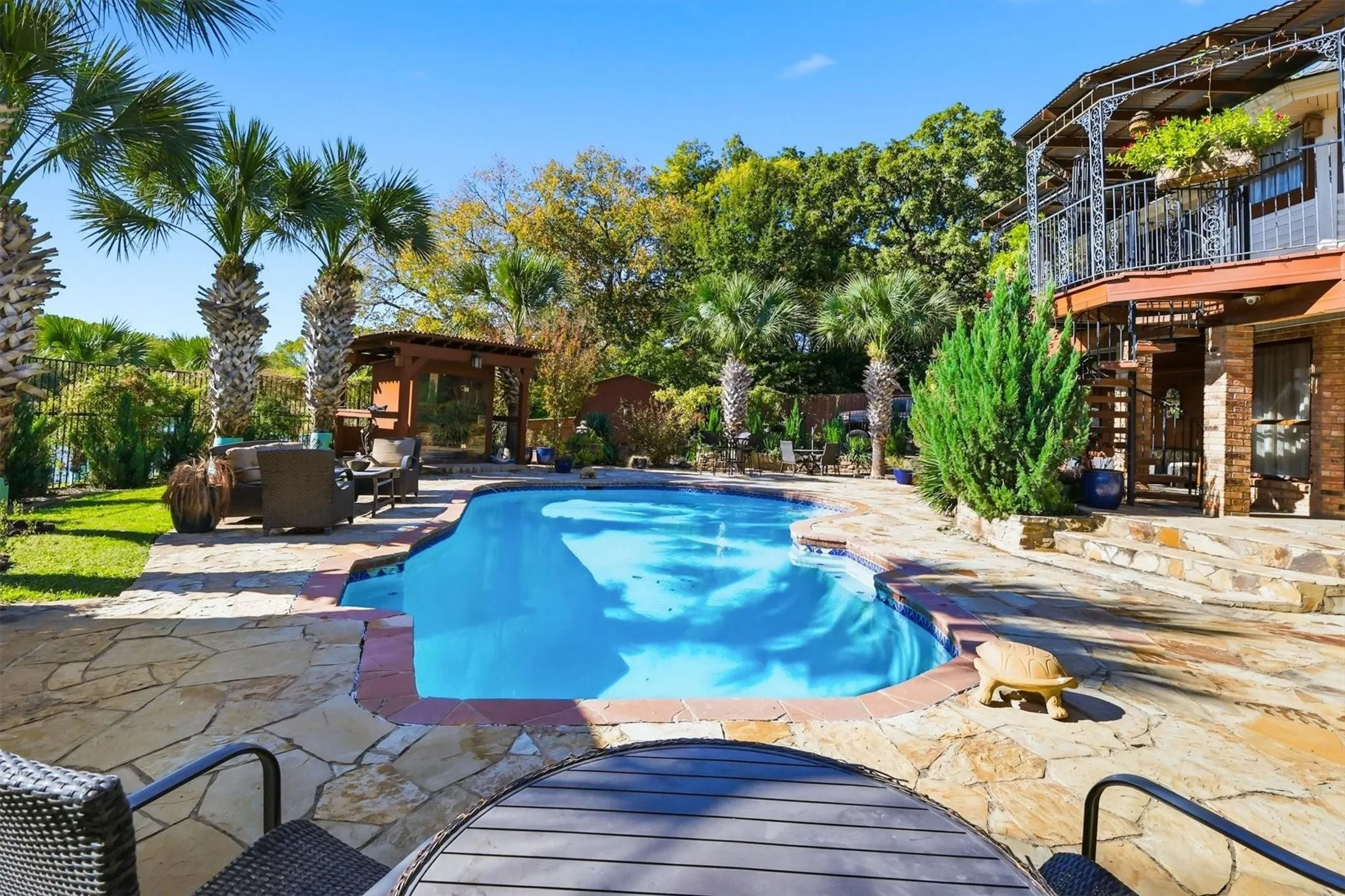 Irregular flagstone patio surrounds a blue-tiled swimming pool