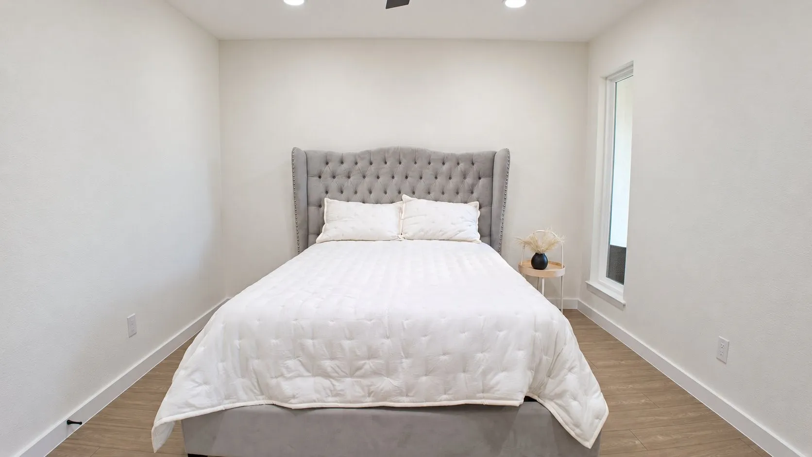 Recessed lighting, ceiling fan, contemporary wall-mounted window, wood-finish flooring, and white wall finishes