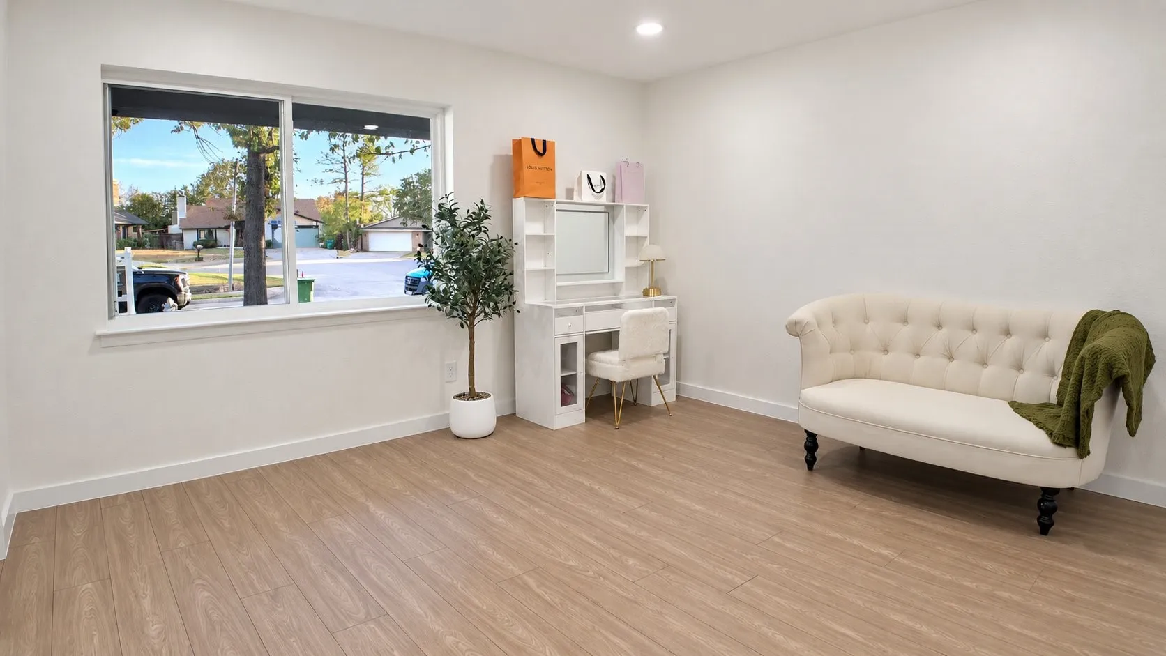 Bright room featuring wood-finish flooring, white walls, and a large window