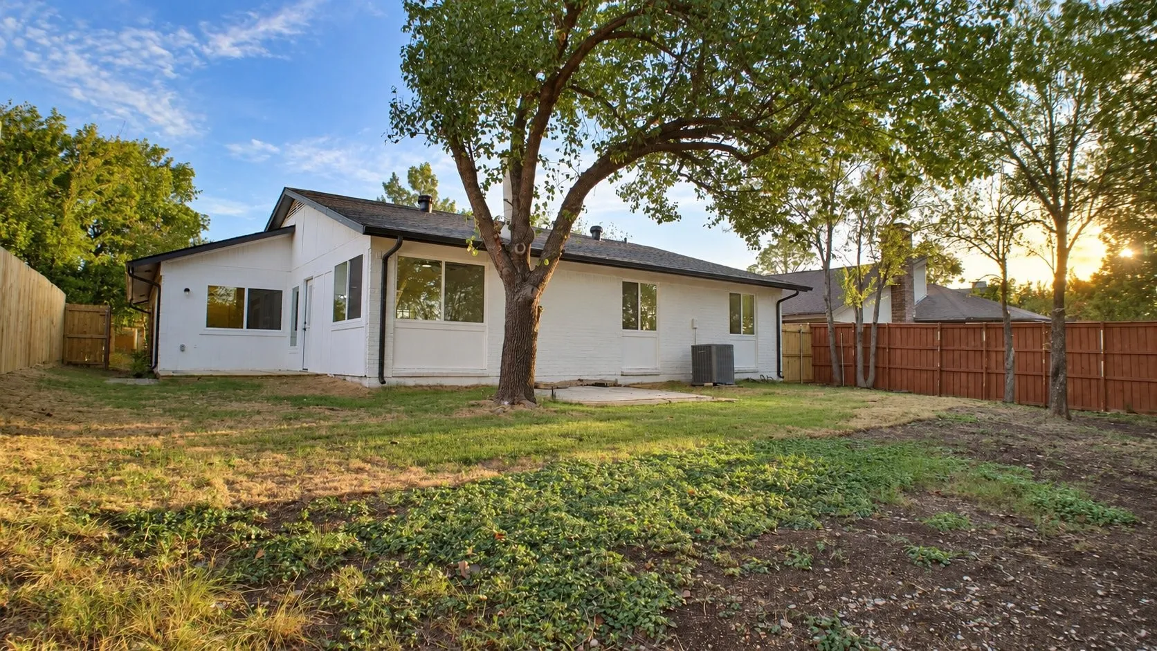 White stucco exterior with black trim, multiple windows, and a black shingle roof