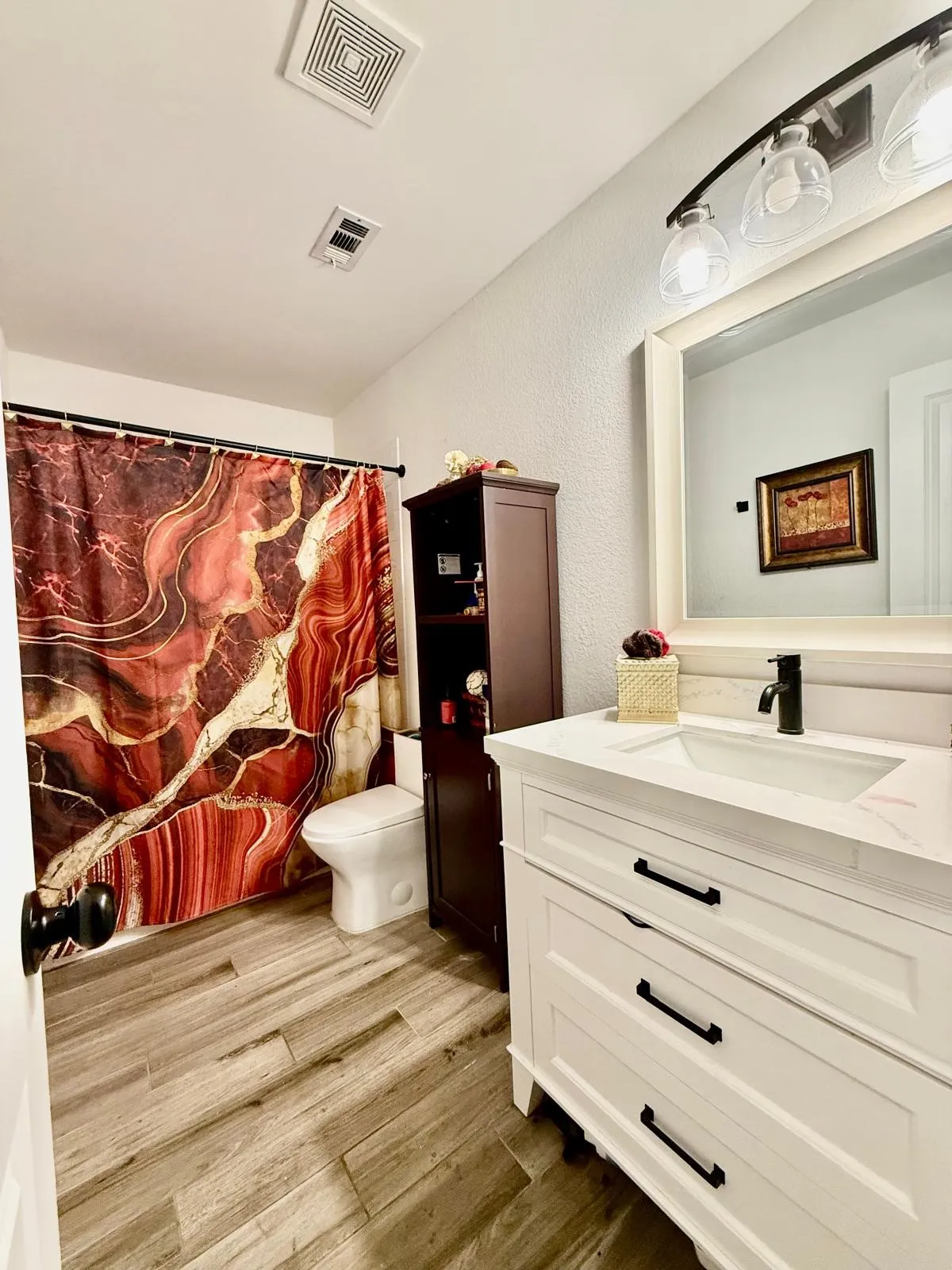 White vanity with black hardware, integrated sink, and black faucet
